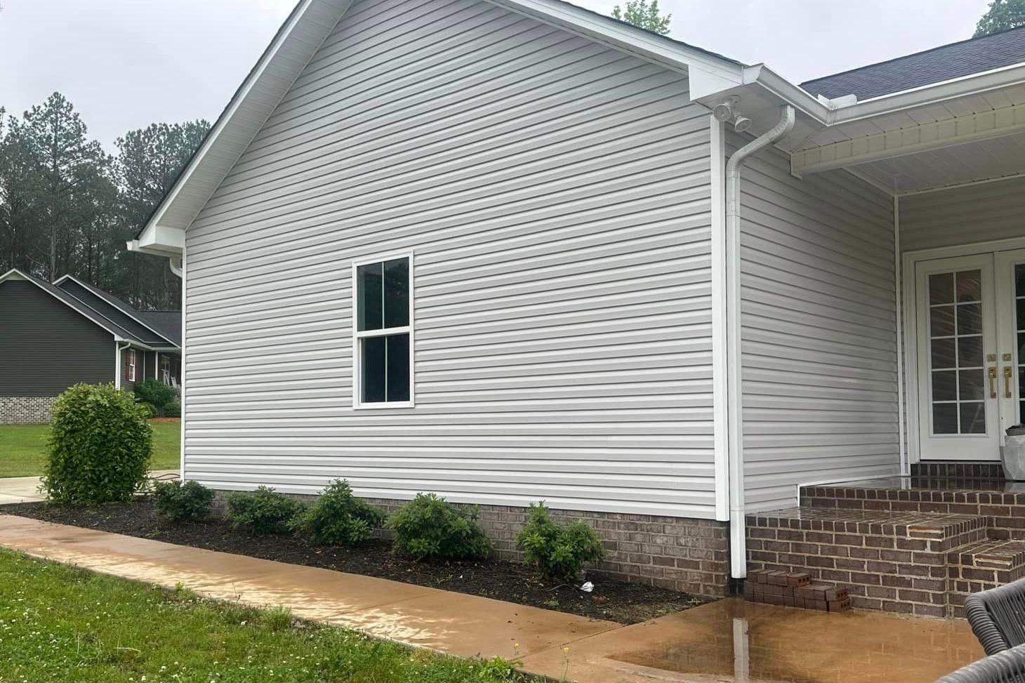 A white house with a blue roof and a walkway leading to it.