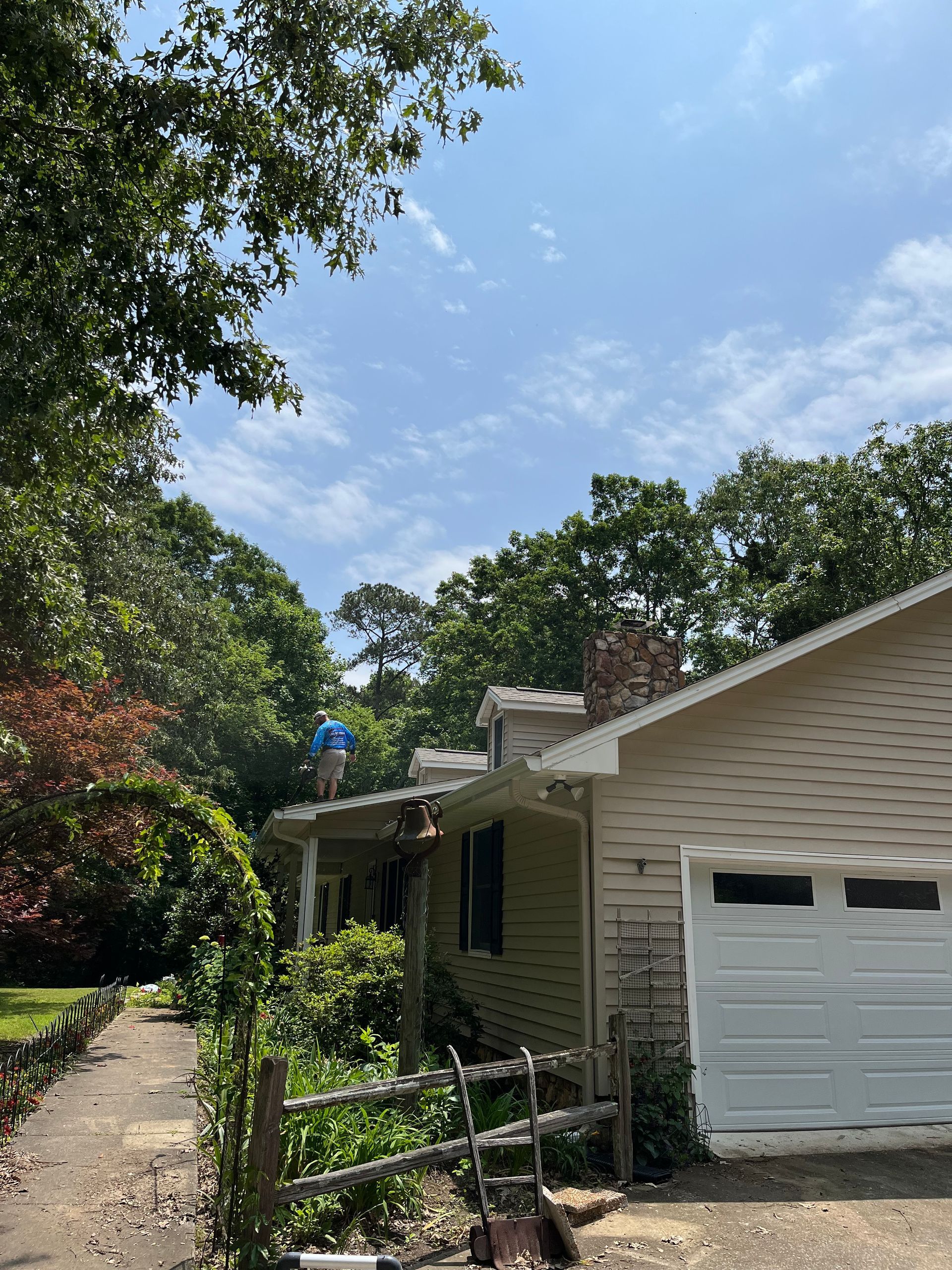 A house with a white garage door and a wooden fence in front of it.