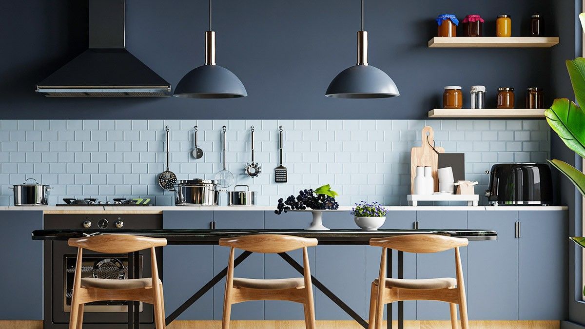 A kitchen with blue cabinets , a table and chairs.