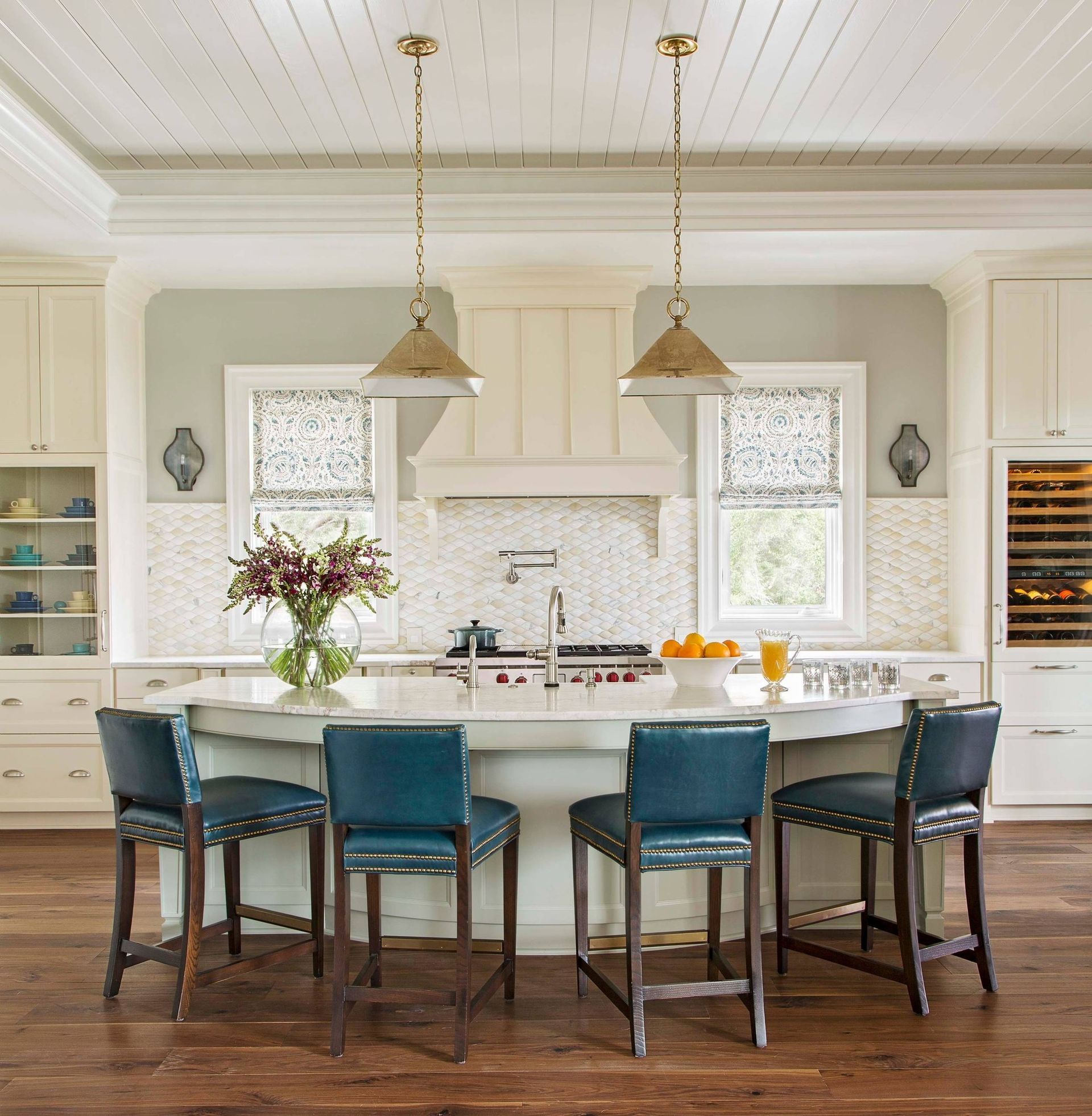 A kitchen with a large island and blue chairs
