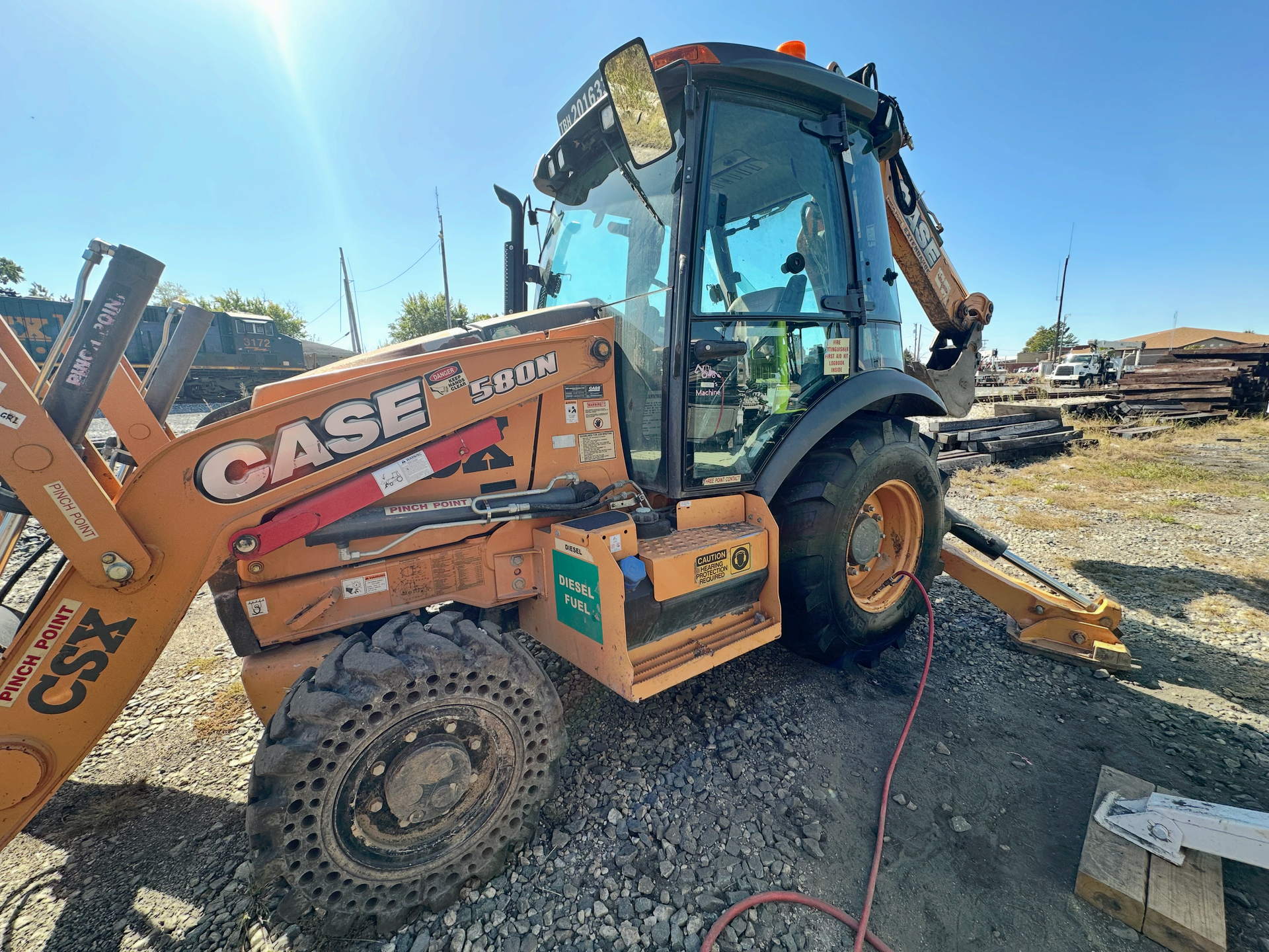 Orange Case backhoe on gravel with blue sky. | Midwest Tire & Service LLC