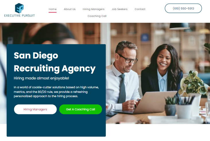 A man and a woman are sitting at a table looking at a laptop.