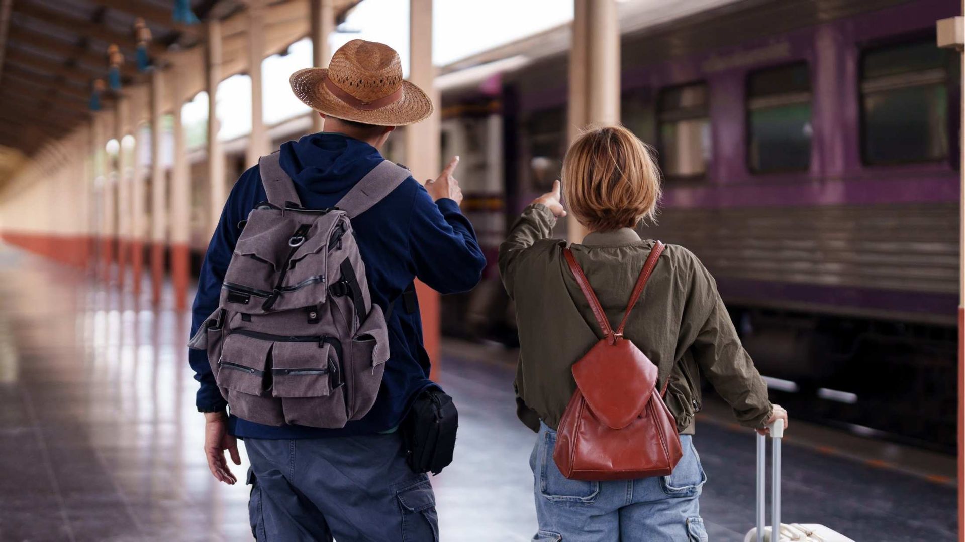 Modern white building with tall blue-tinted windows against a partly cloudy sky.