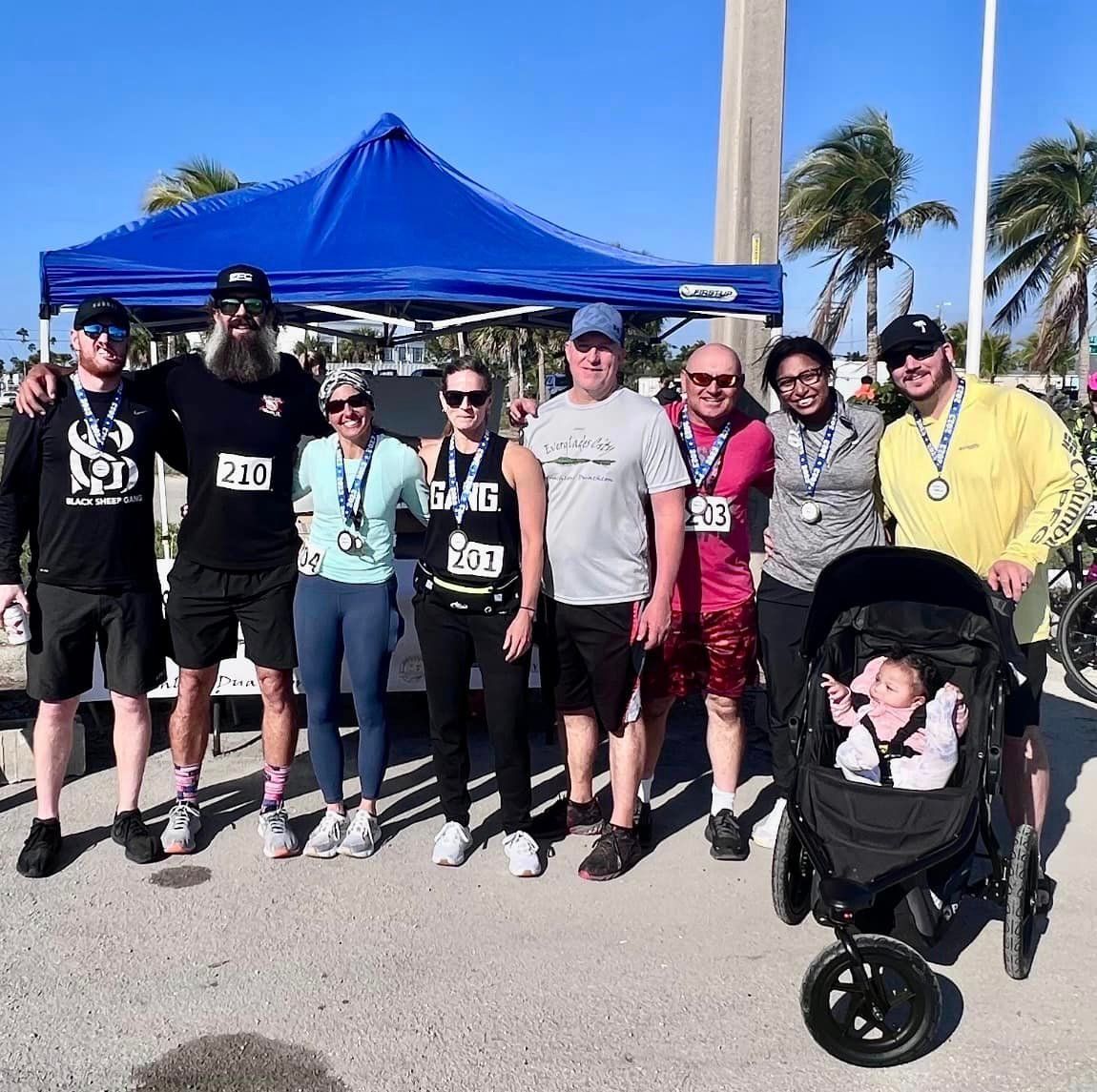A group of people posing for a picture with a baby in a stroller