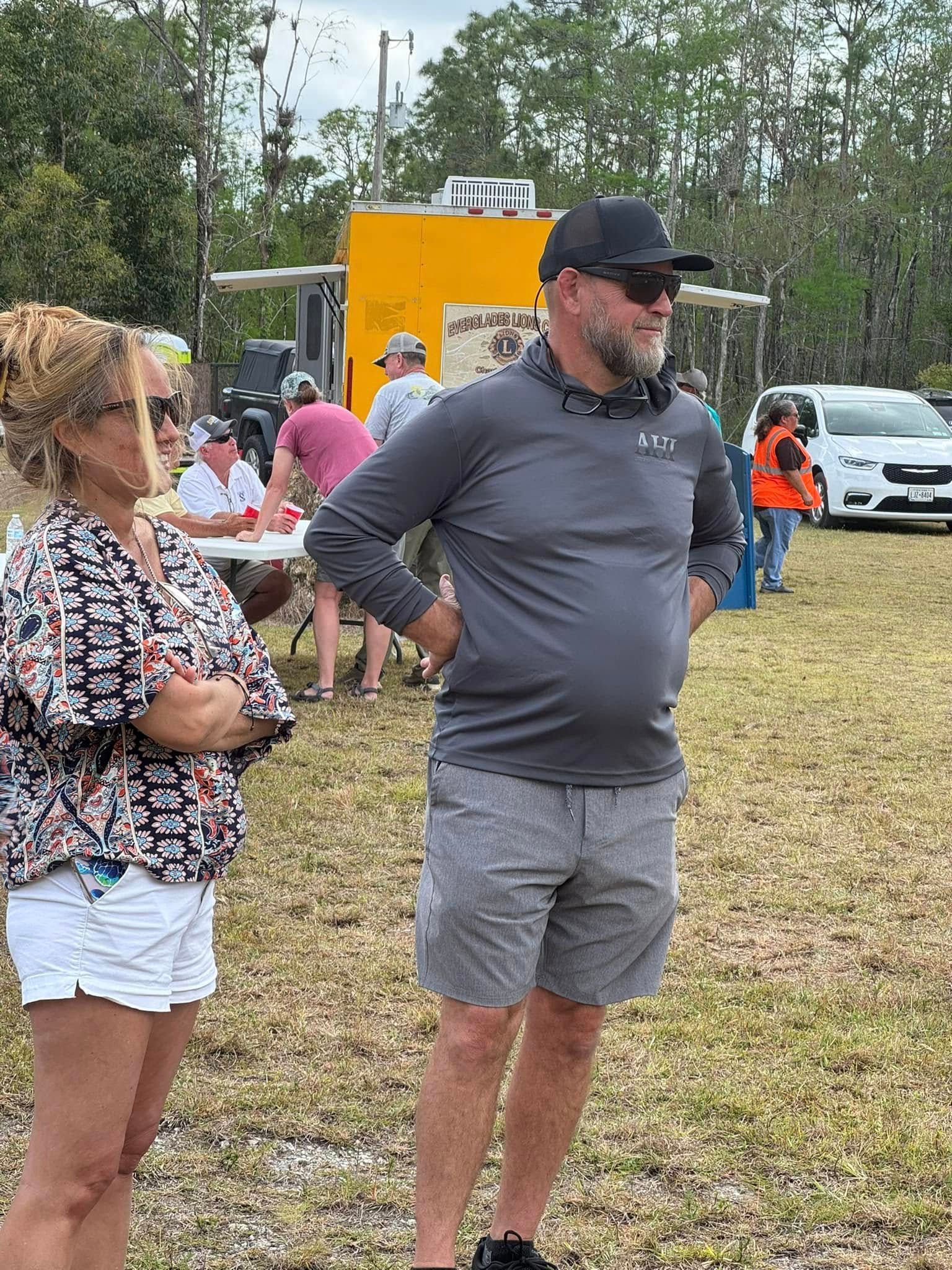 A man and a woman are standing next to each other in a field.