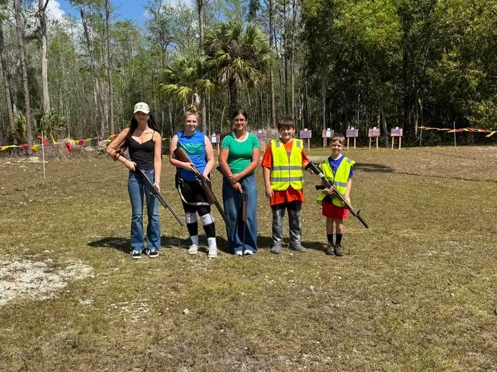 children in a line with guns