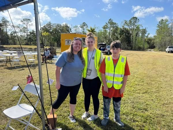 A group of people are posing for a picture in a field.