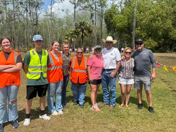 A group of people are posing for a picture in a field.
