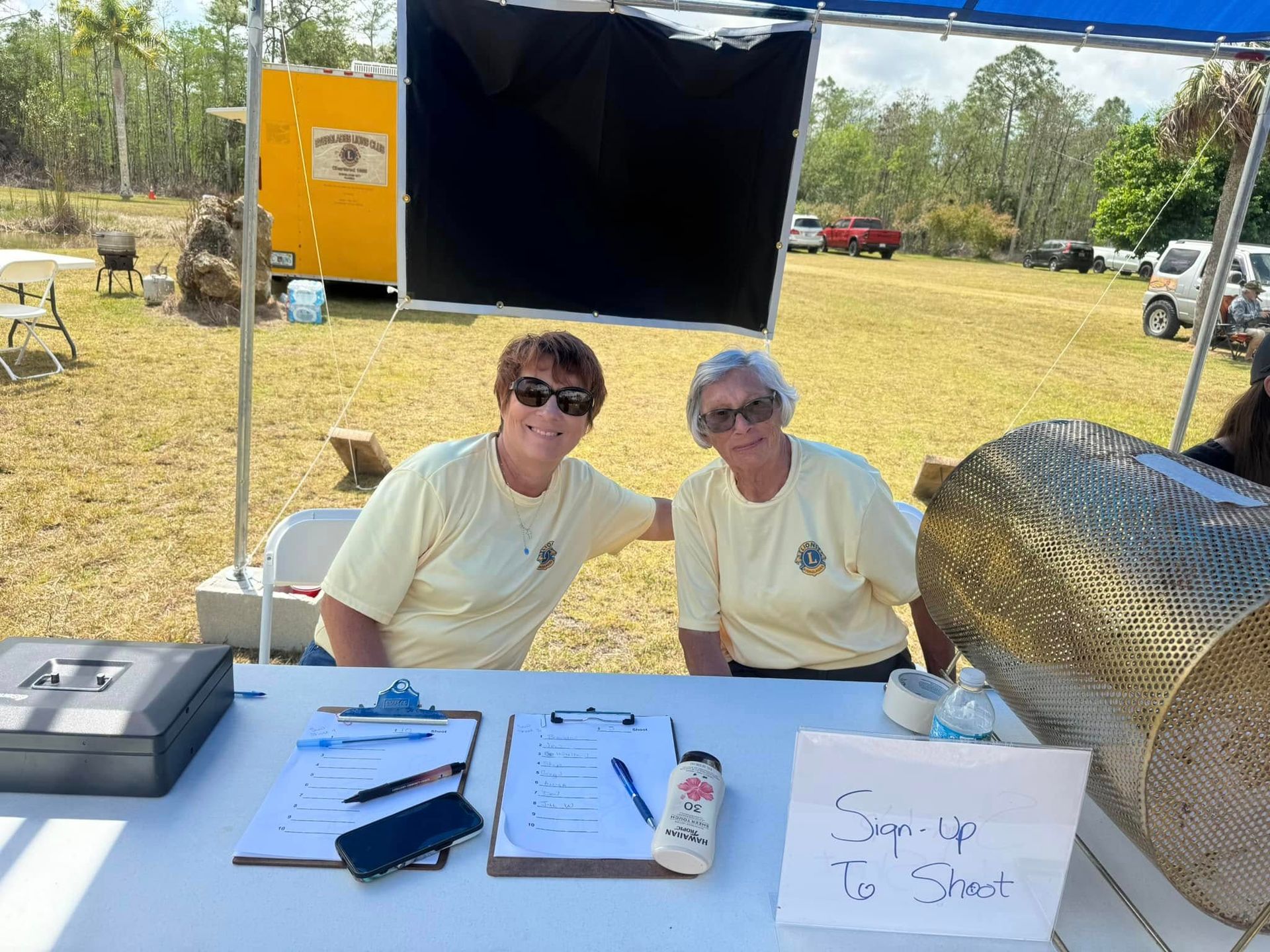 Two women sitting at a table with a sign that says copy up to your