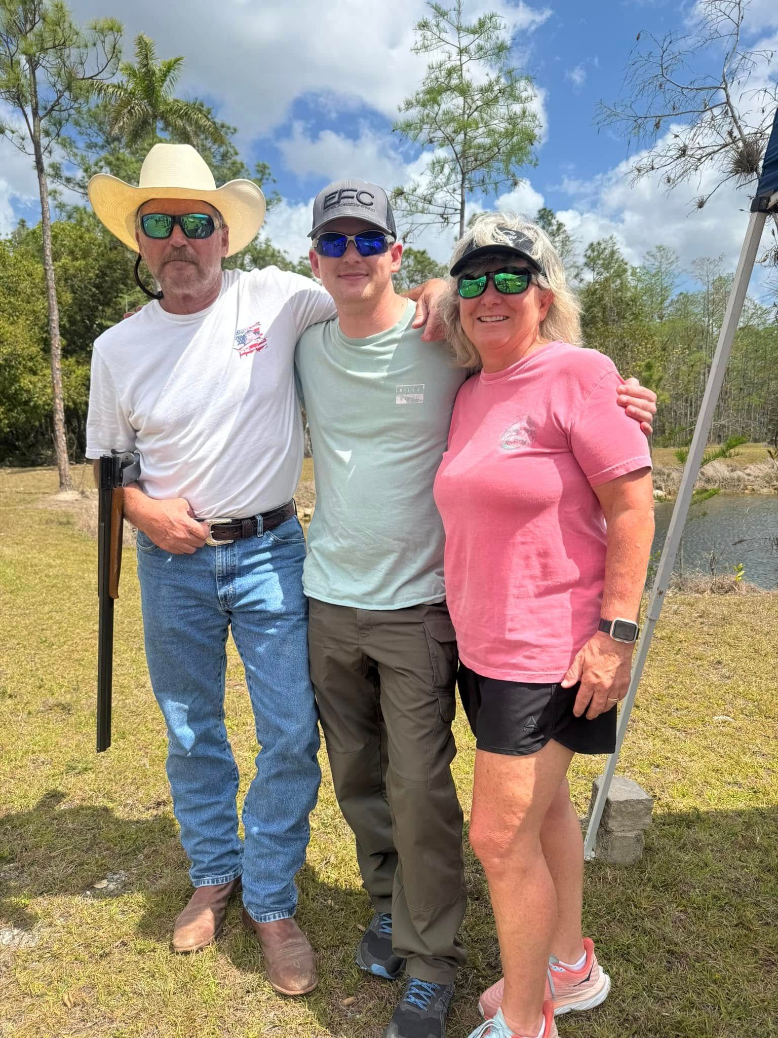A group of people are posing for a picture in a field.