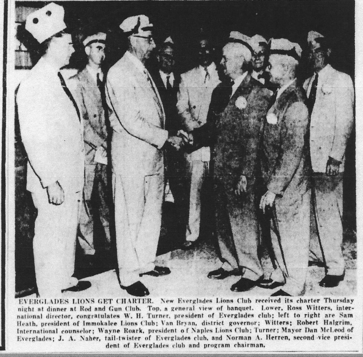 A group of men are shaking hands in a black and white photo