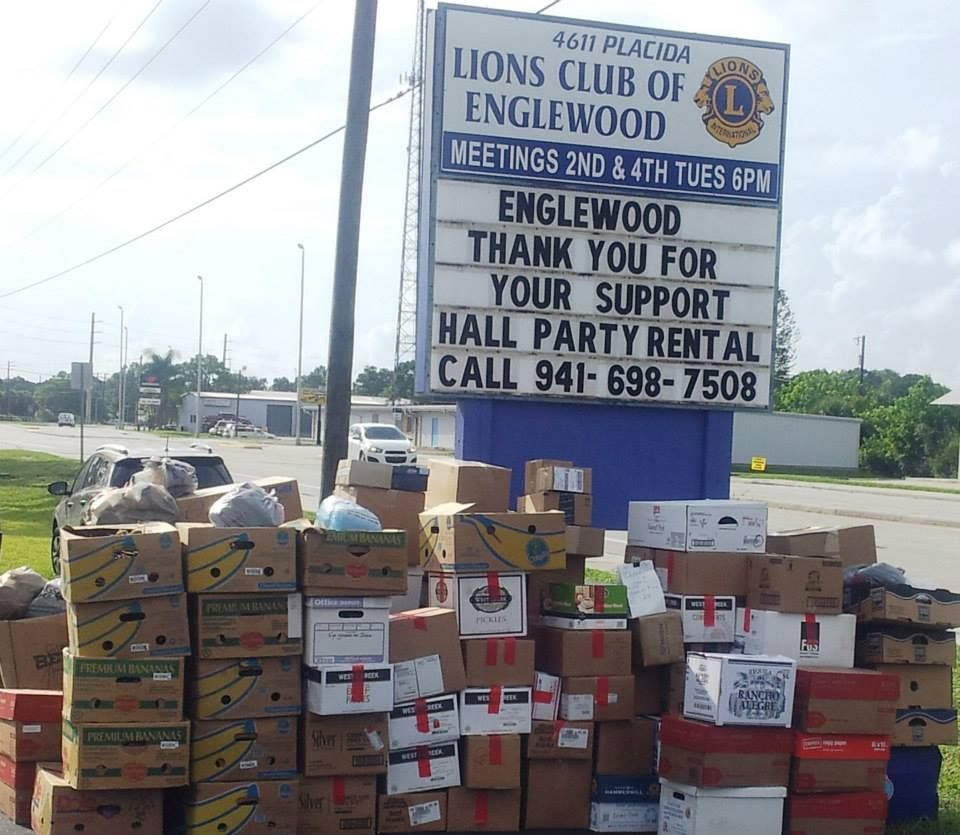 Boxes are stacked in front of a sign for the lions club of englewood