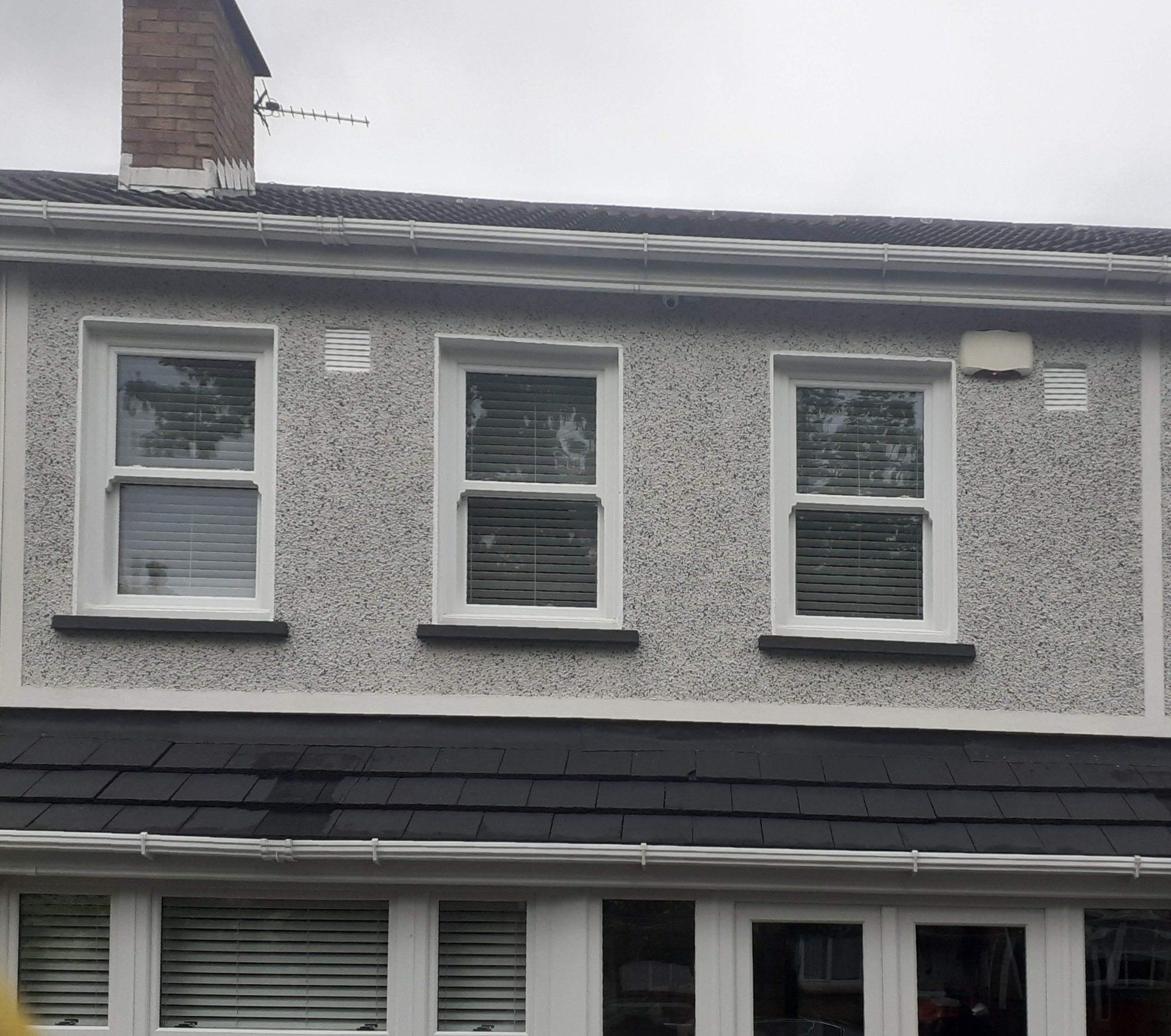 A house with a chimney on top of it and a lot of windows