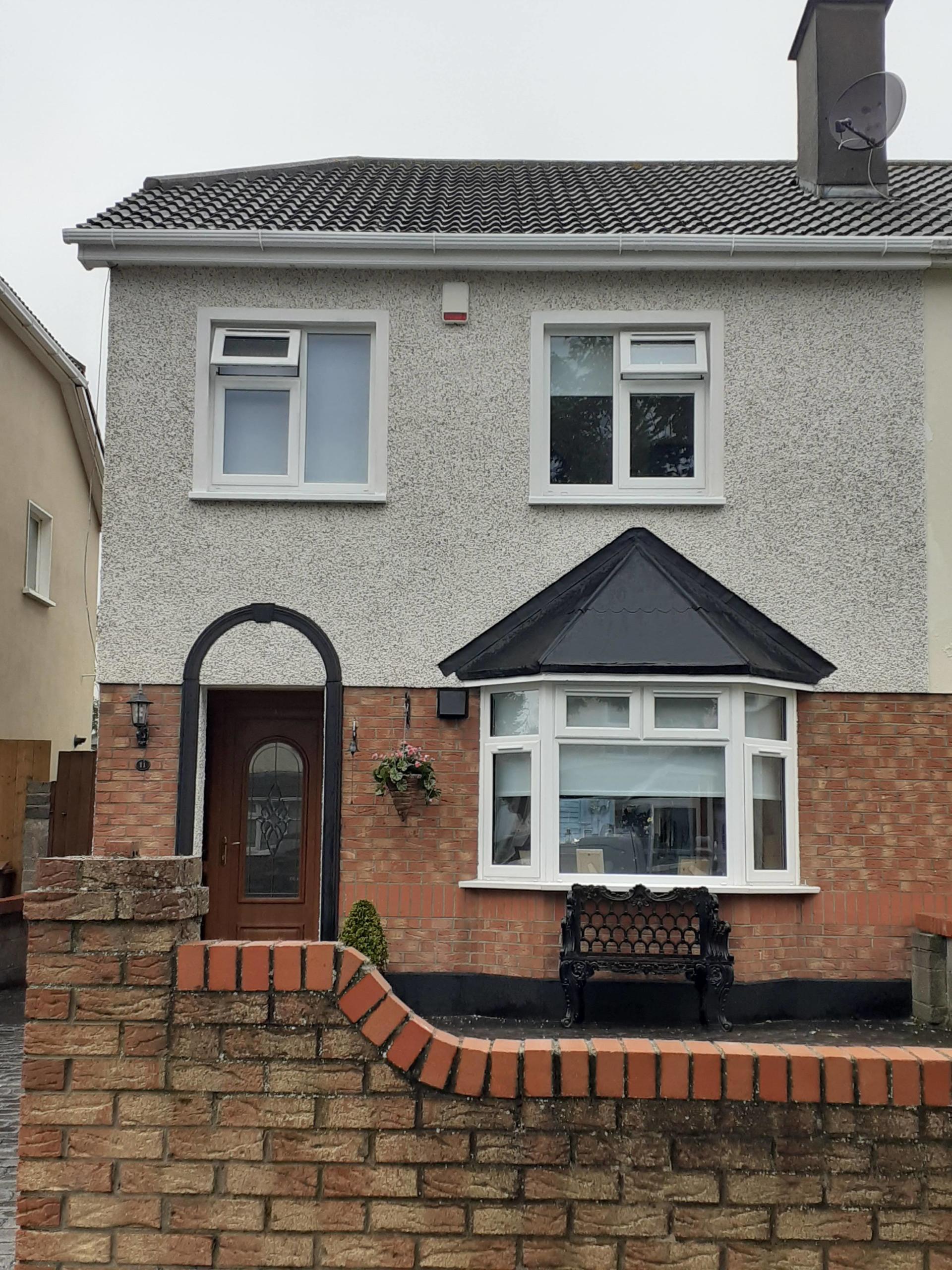 A house with a brick wall in front of it