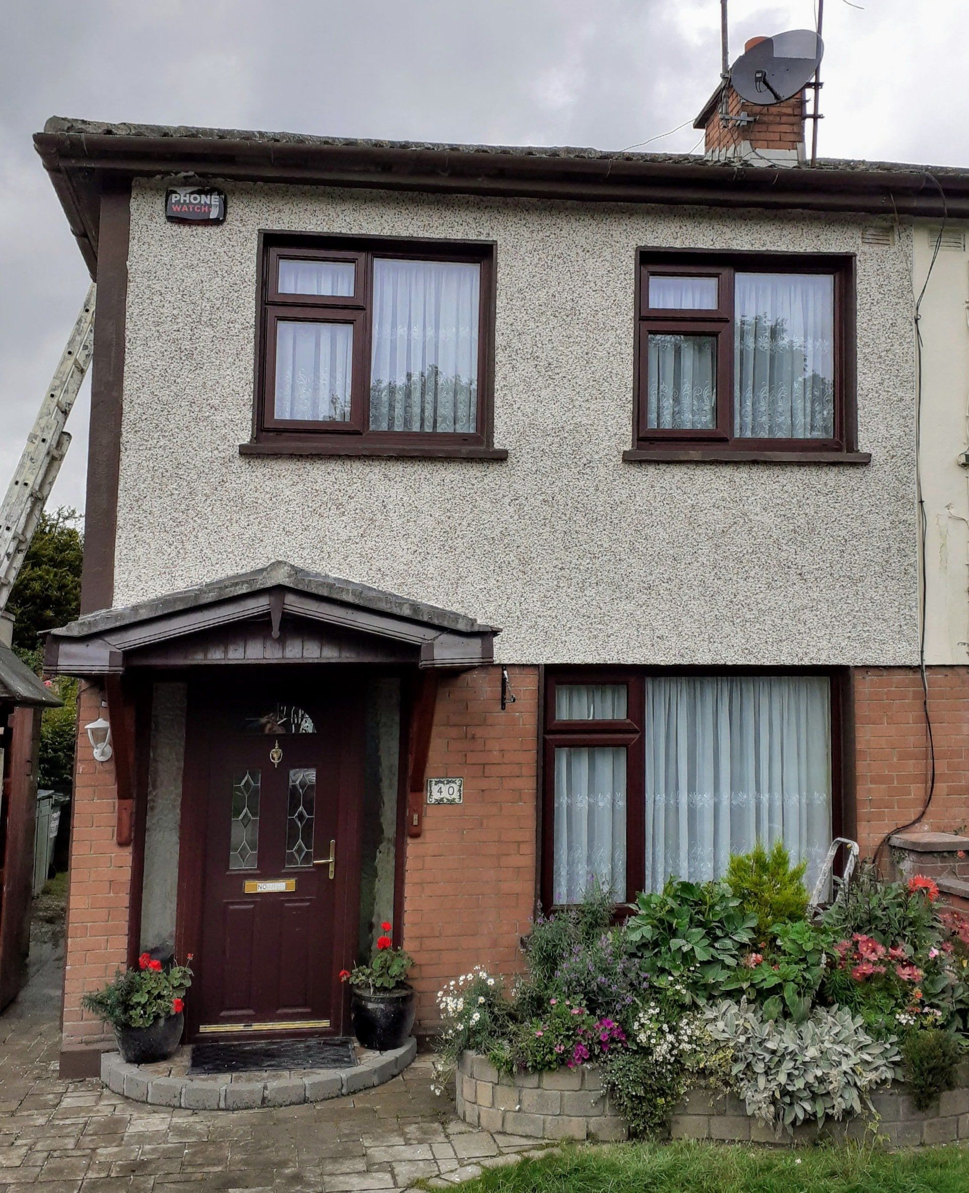 A house with a porch and flowers in front of it