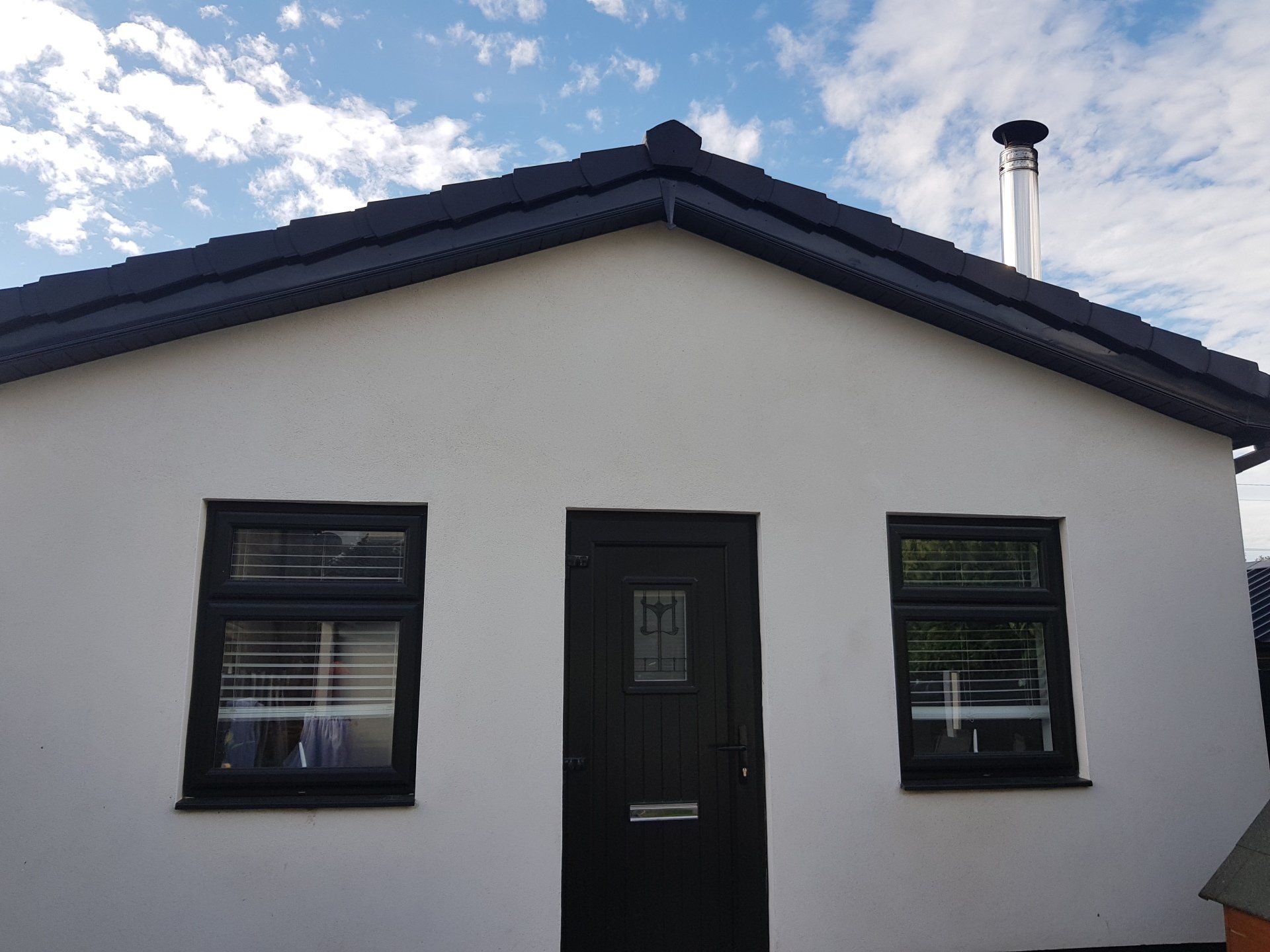 A white house with black windows and a black door.