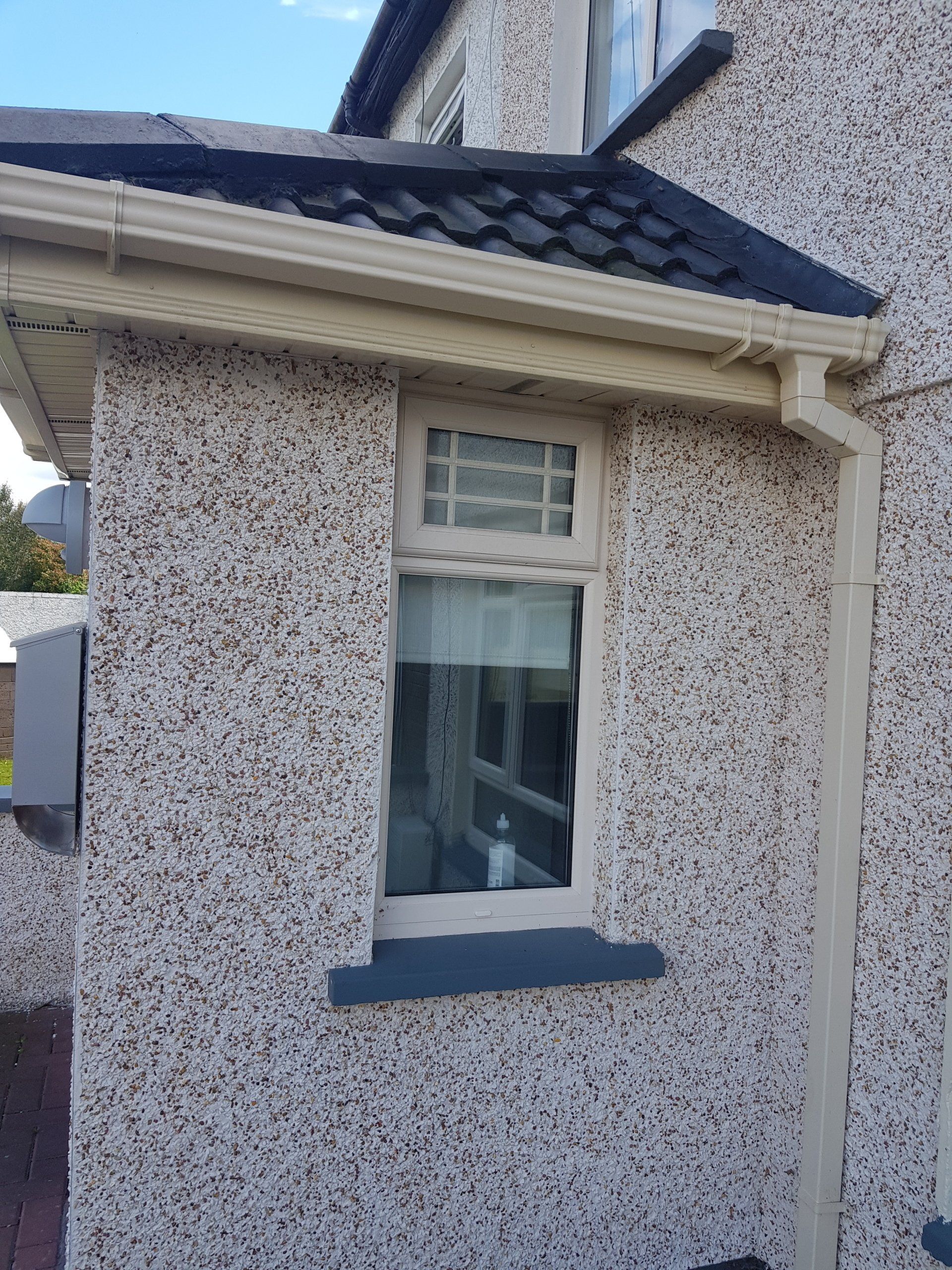 A house with a window and gutter on the side of it.