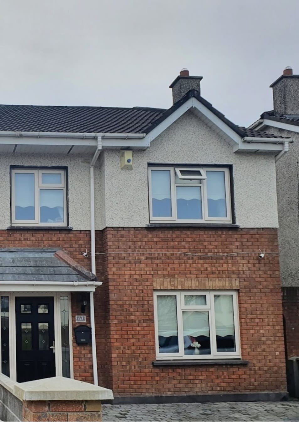 A brick house with a gray roof and white trim
