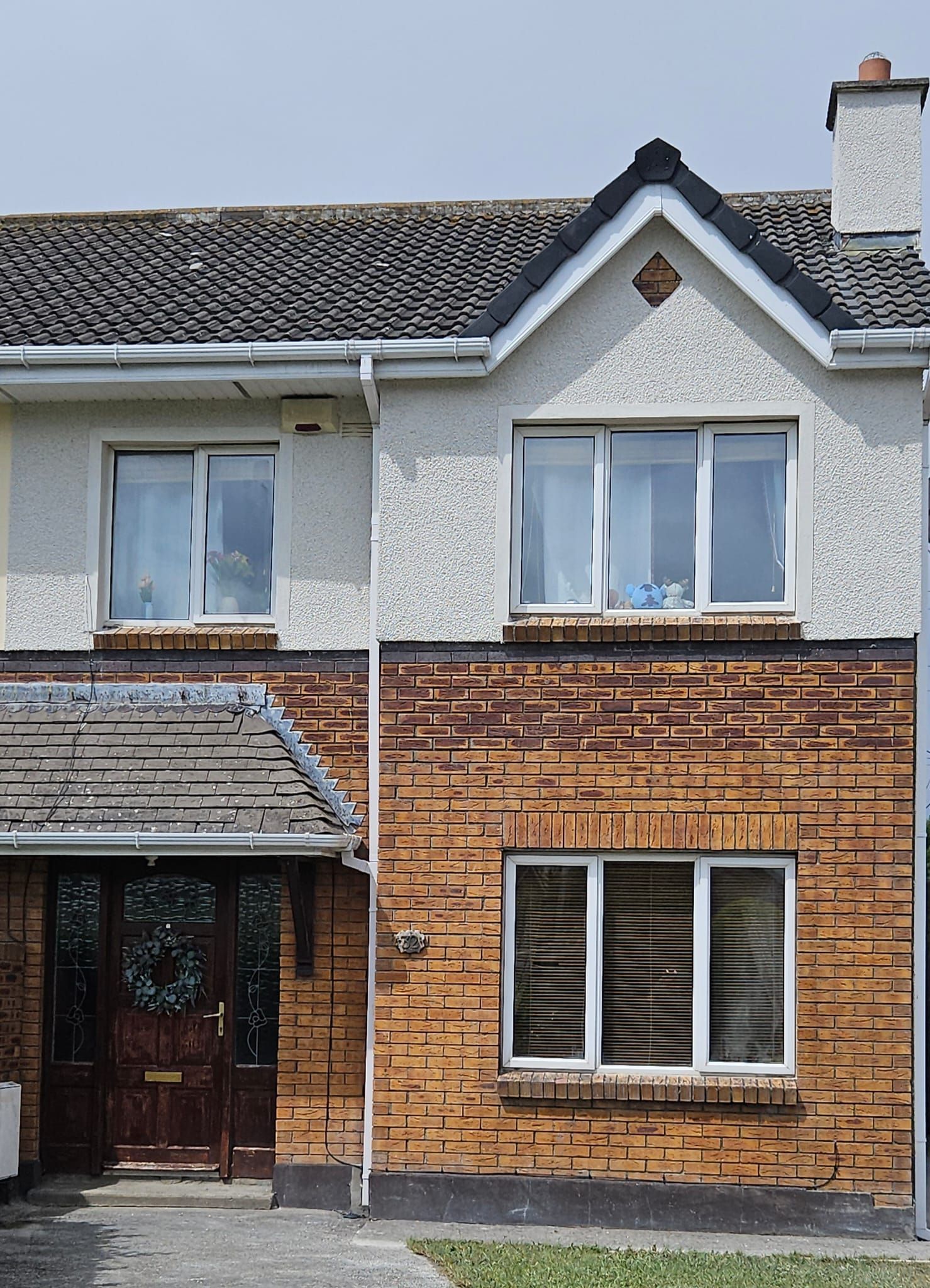 A brick house with a white roof and a lot of windows