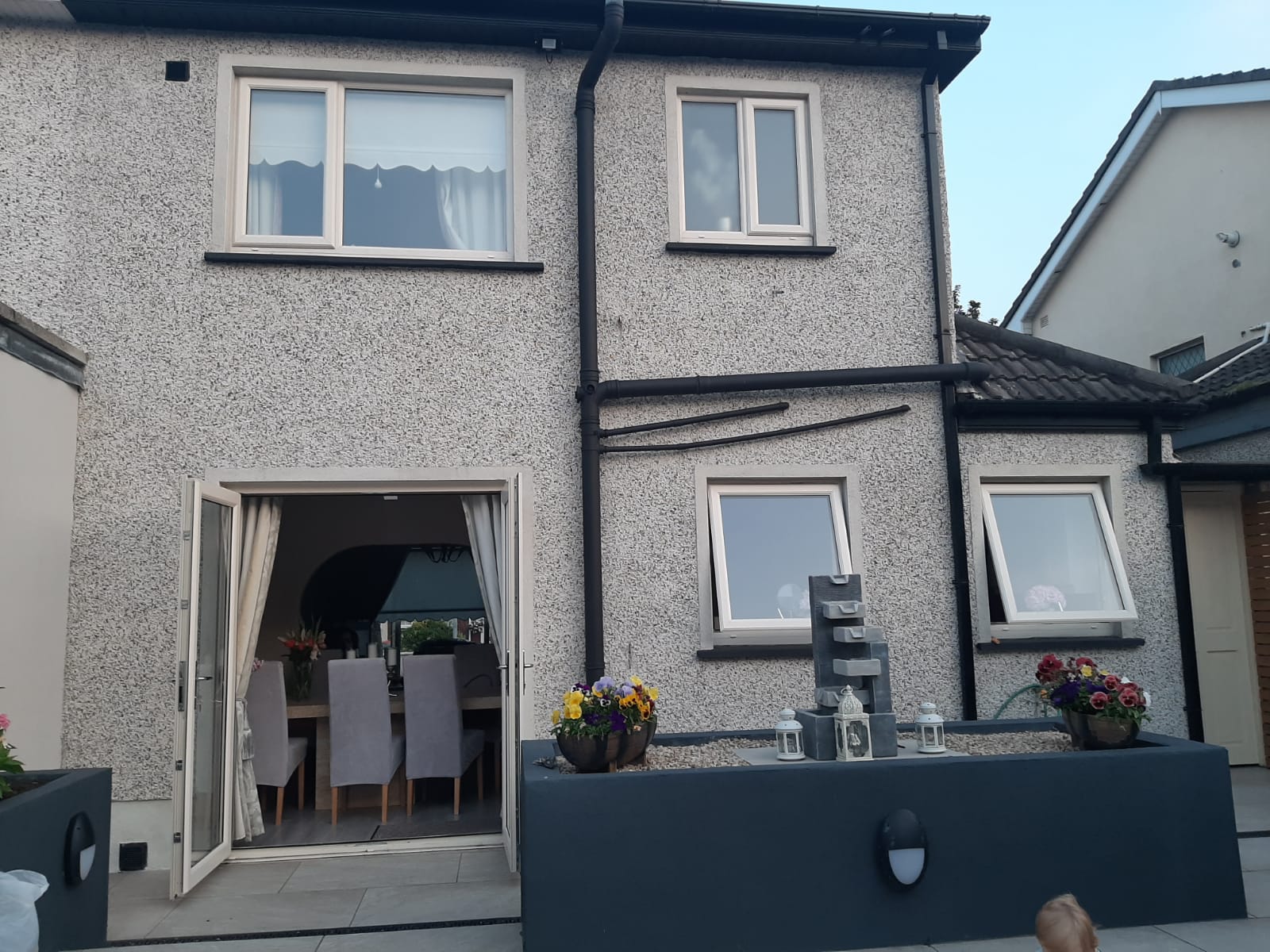 A house with a dining table and chairs in front of it