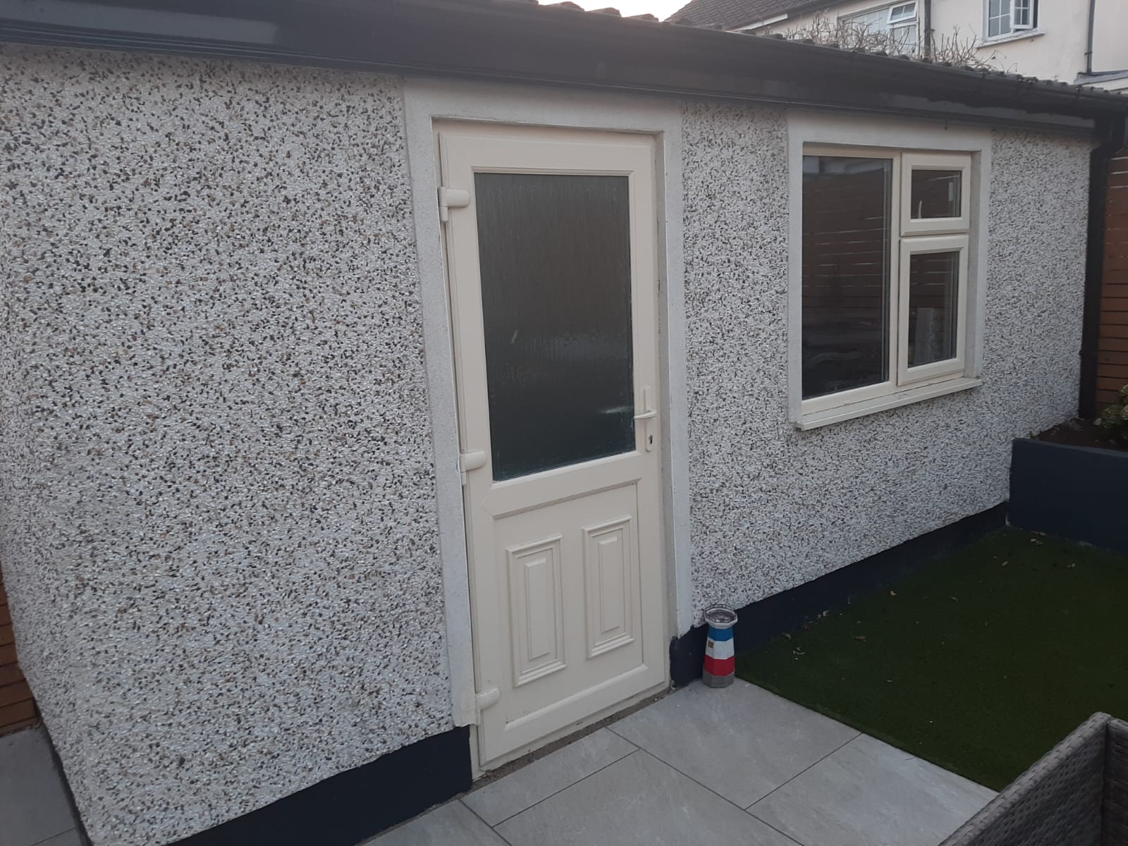 A small building with a white door and a window.