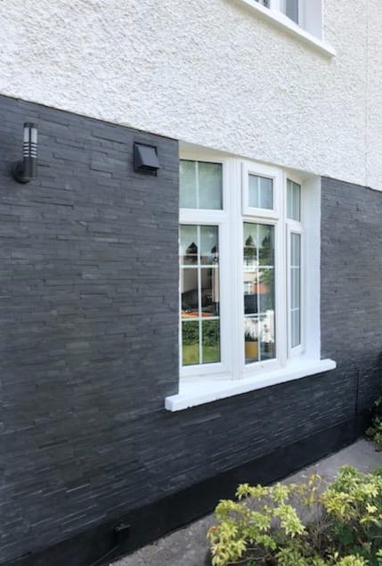 A white window is on the side of a house.