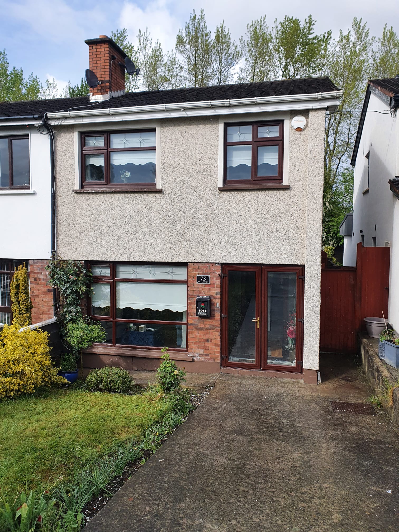 A house with a lot of windows and a driveway in front of it