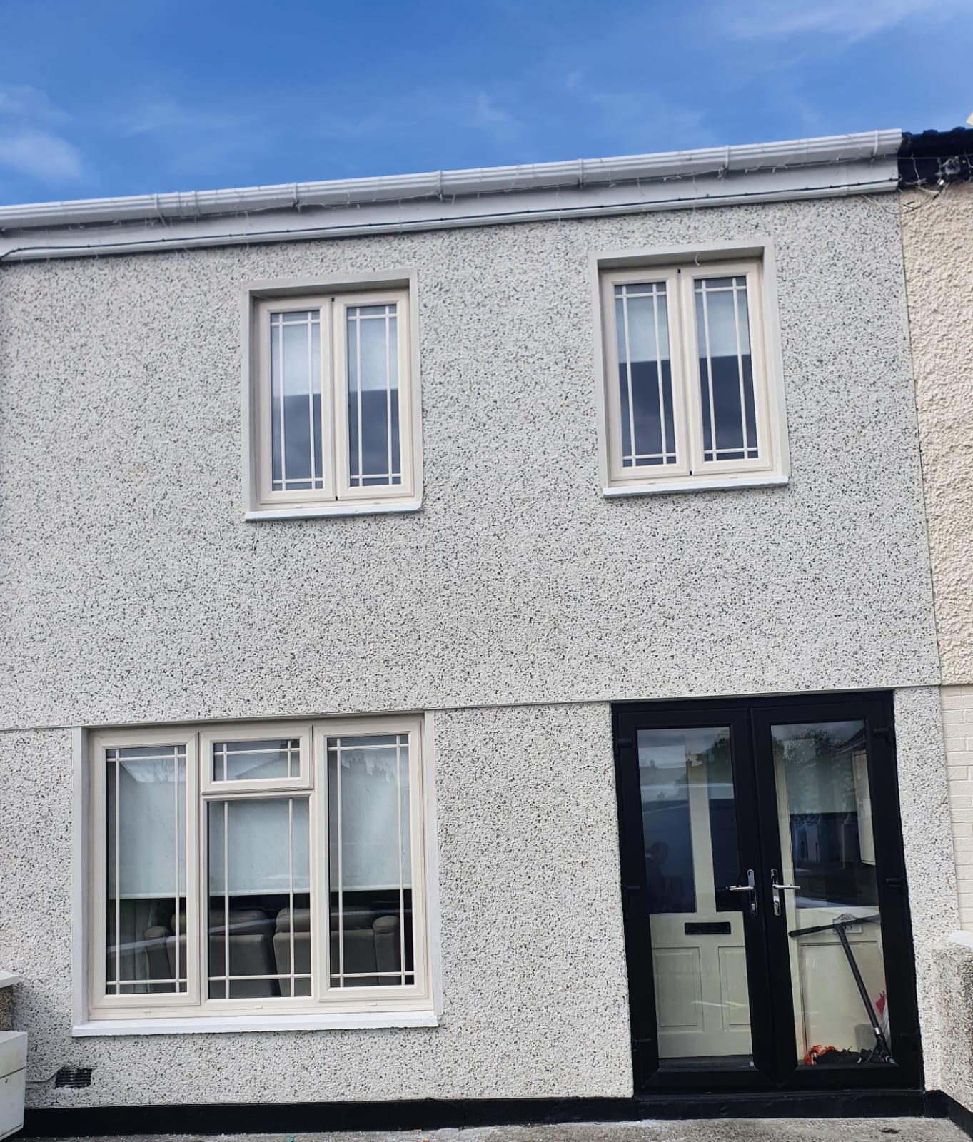 A house with two windows and a black door