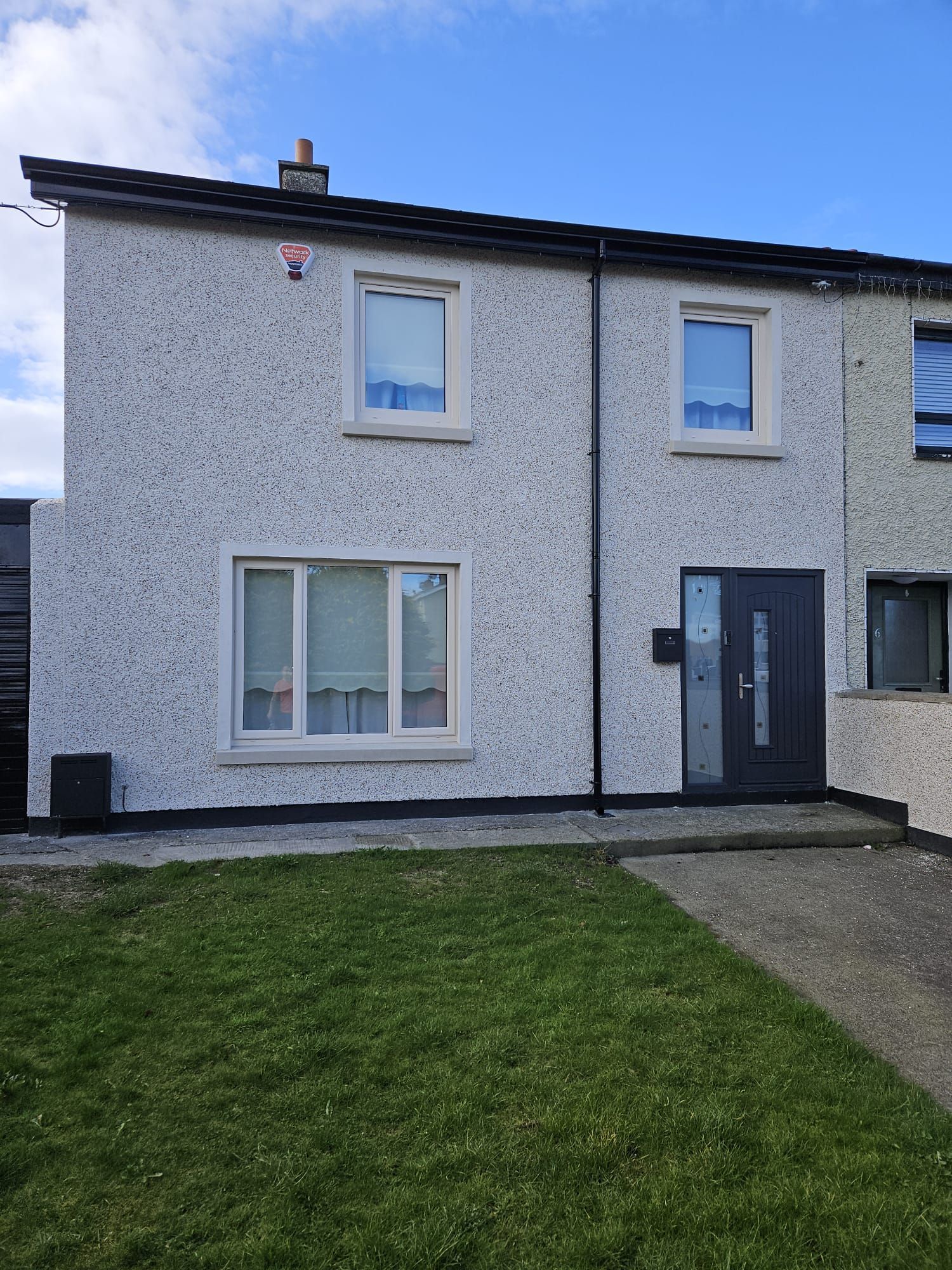 A house with a lot of windows and a lawn in front of it.