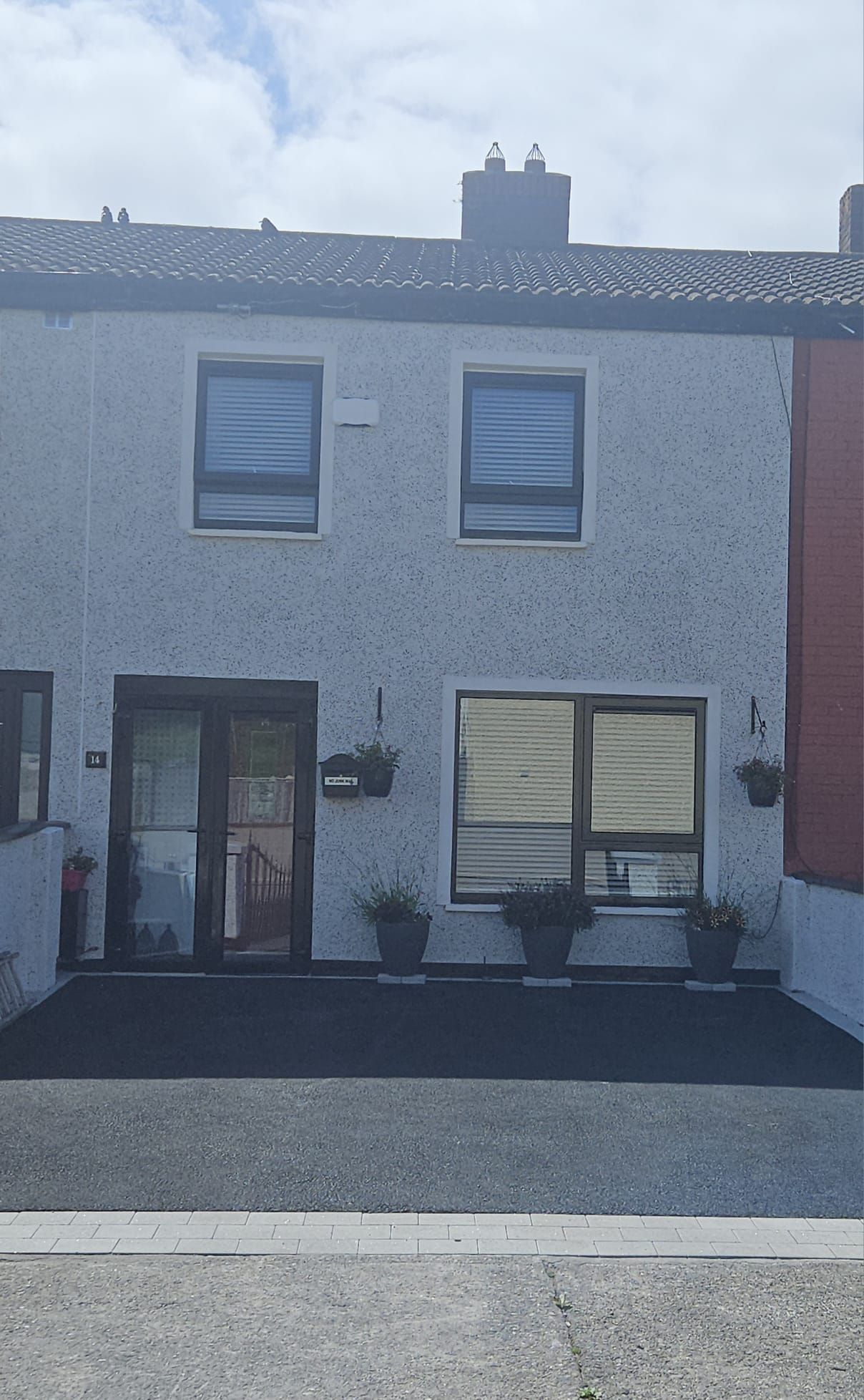 A white house with a lot of windows and a driveway.