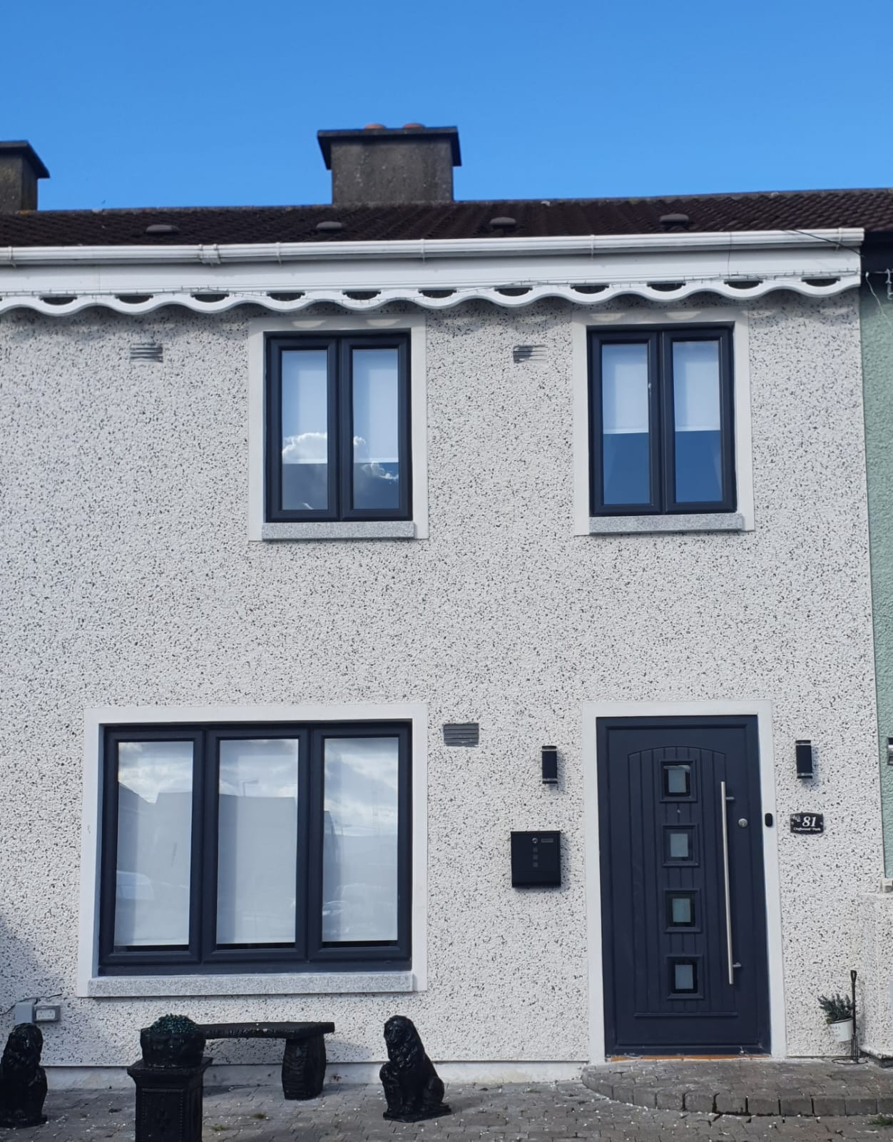 A white house with black windows and a black door.