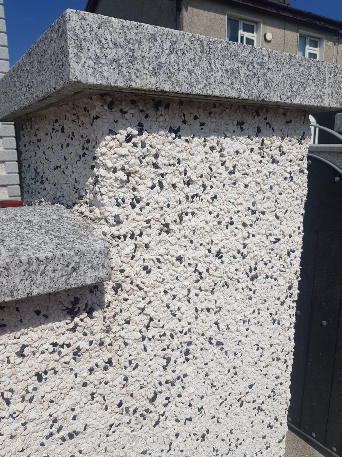 A close up of a white wall with black spots on it