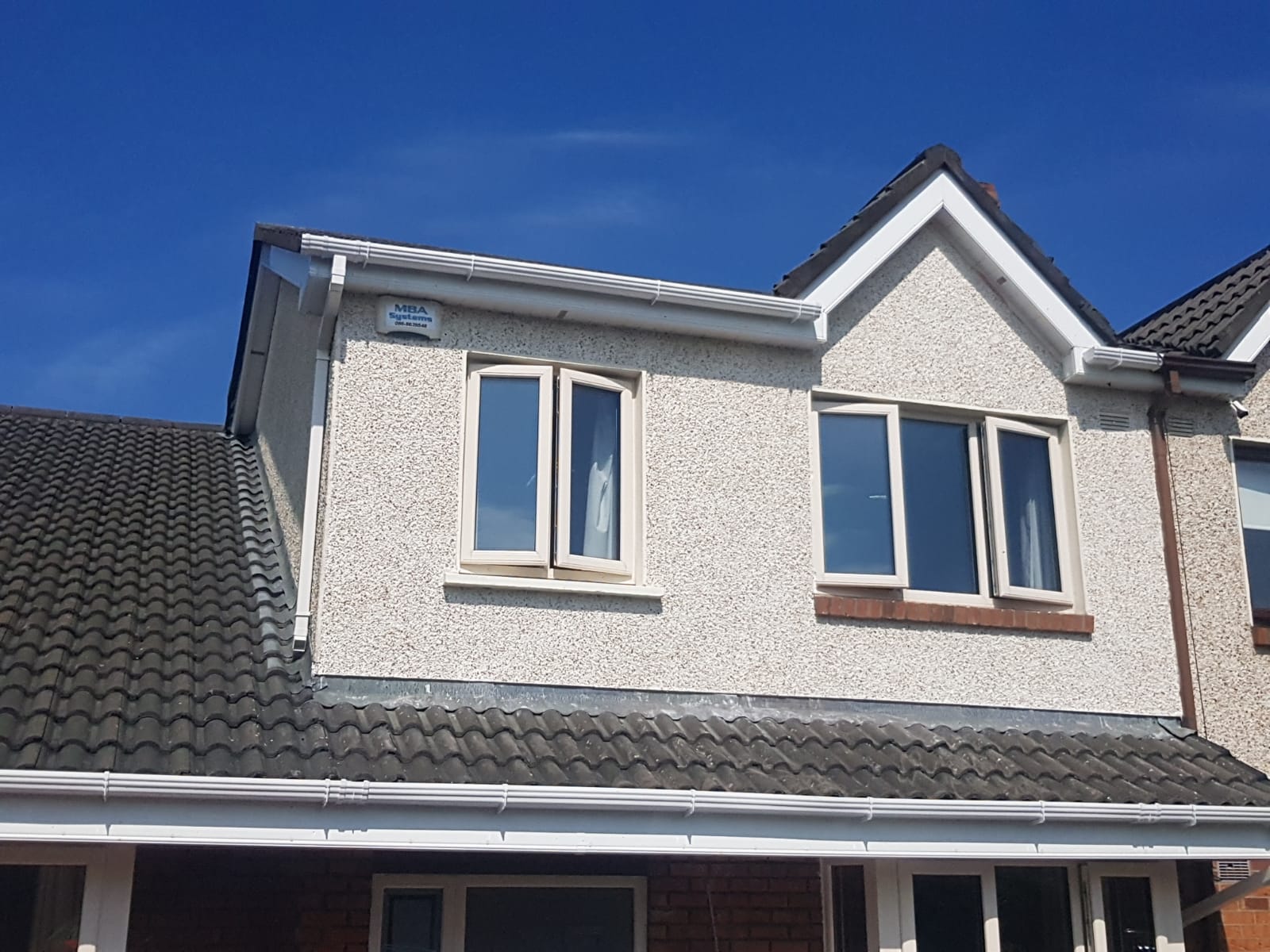 A house with a lot of windows and a blue sky in the background
