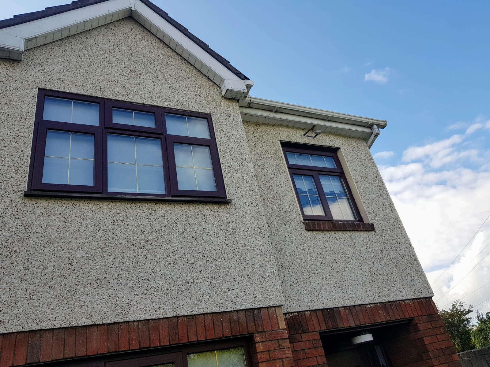 A house with two windows and a blue sky in the background