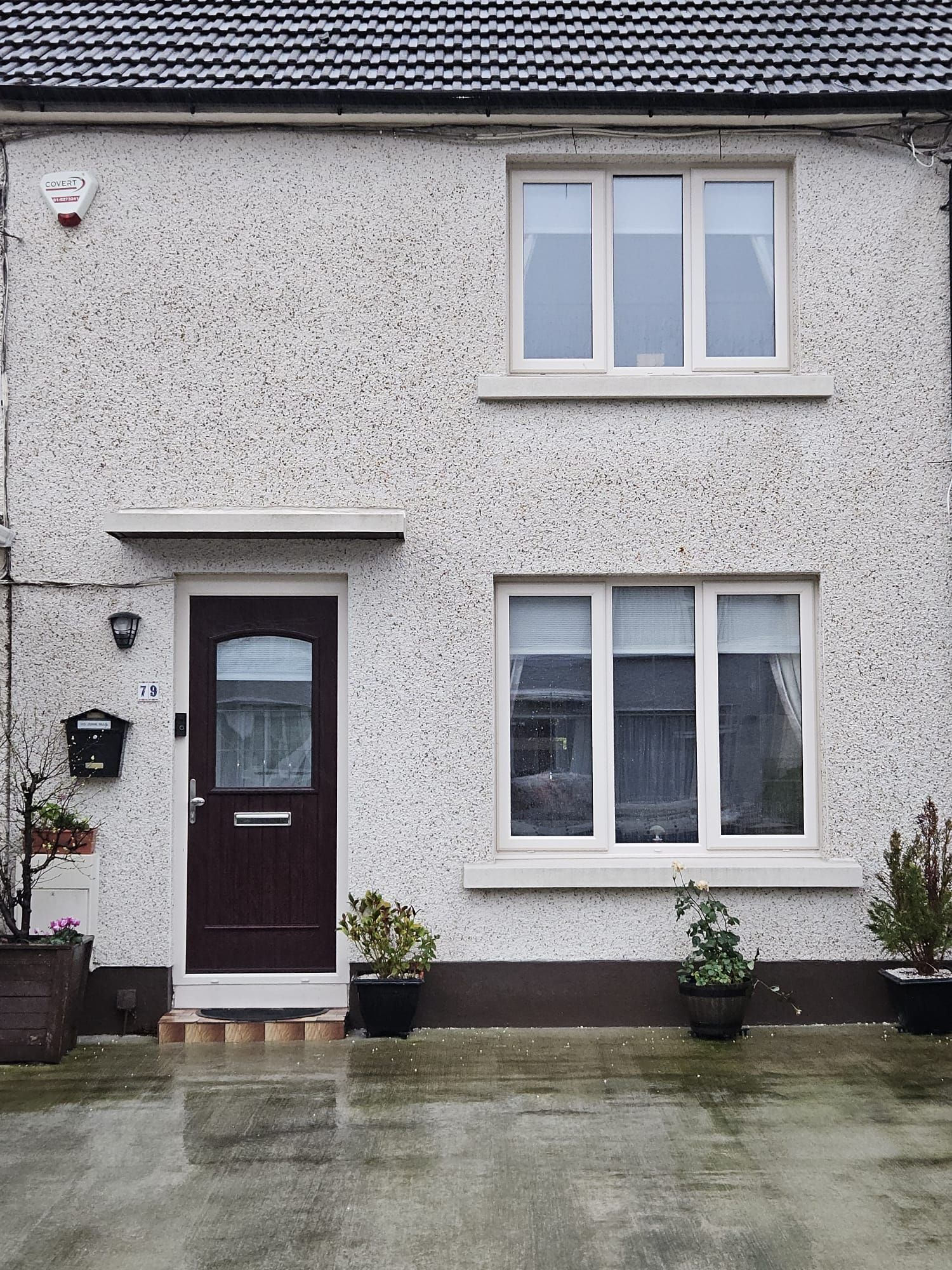 A white house with a brown door and white windows