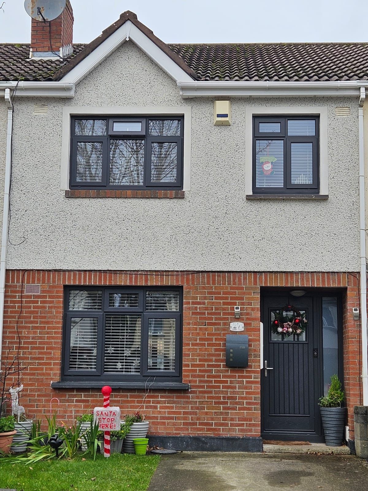 The front of a brick house with a black door and windows