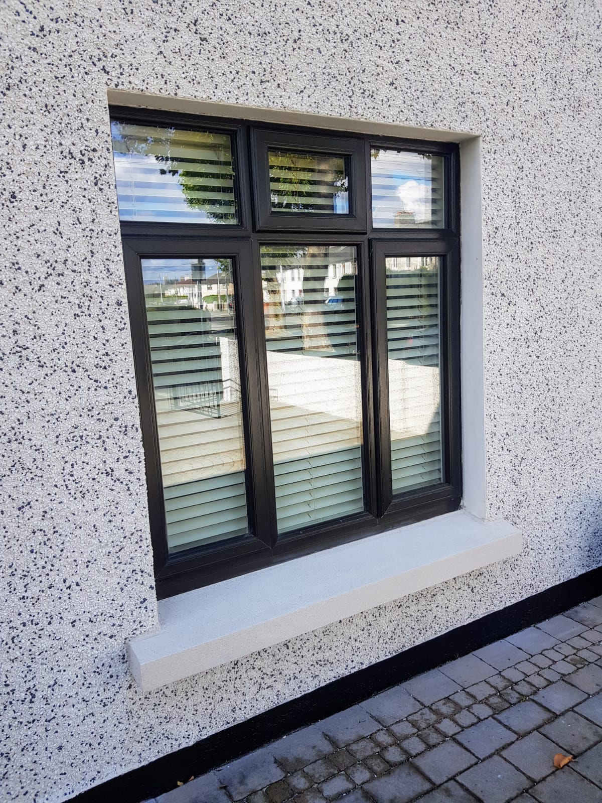 A window with blinds on it is on the side of a building.