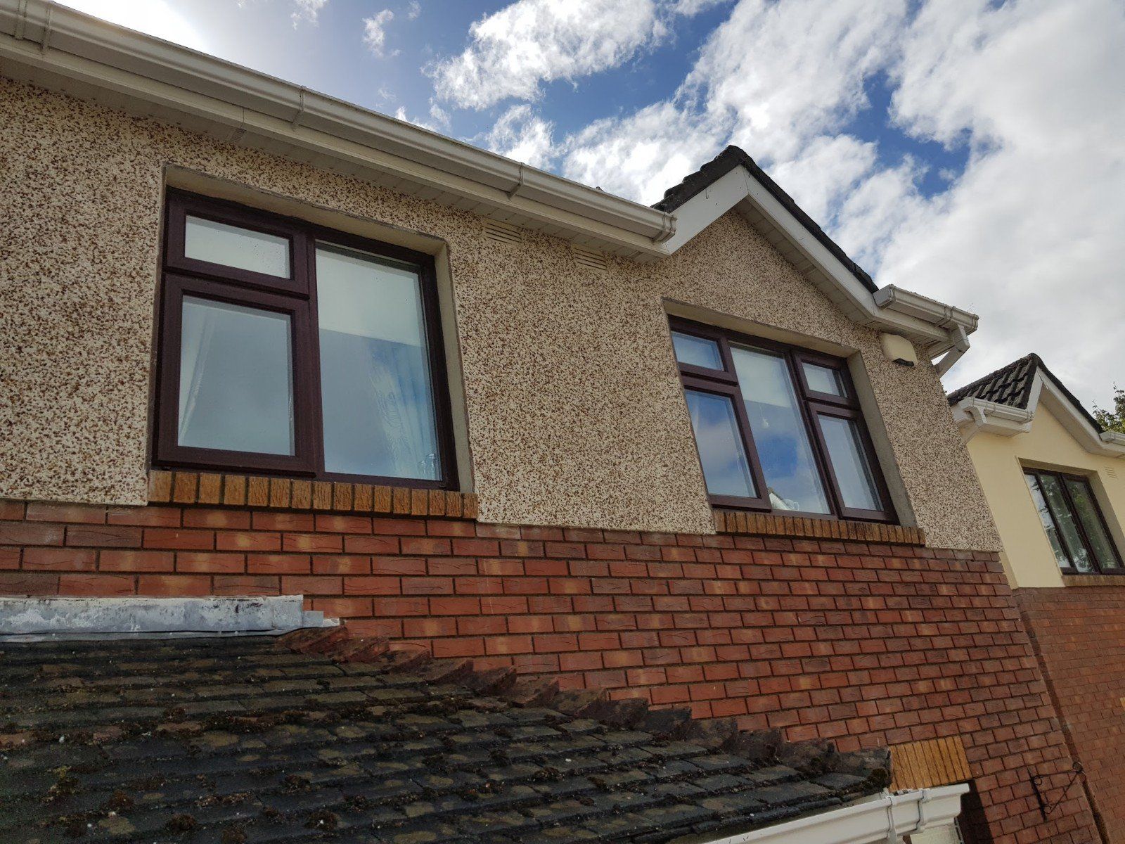 A house with a brick wall and a window on the side of it.