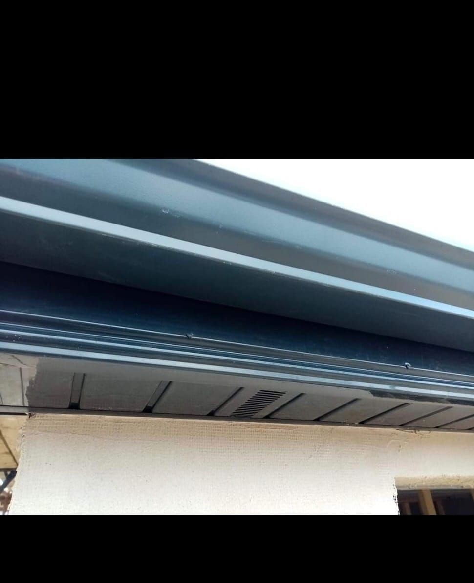 A close up of a gutter on the side of a house.