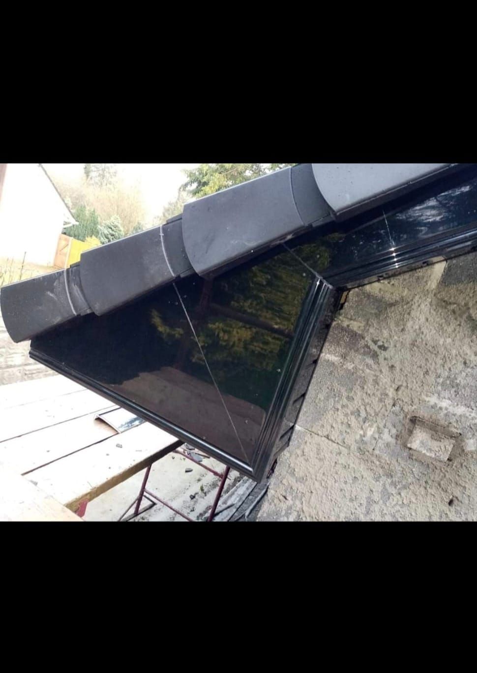 A close up of a black gutter on a roof.