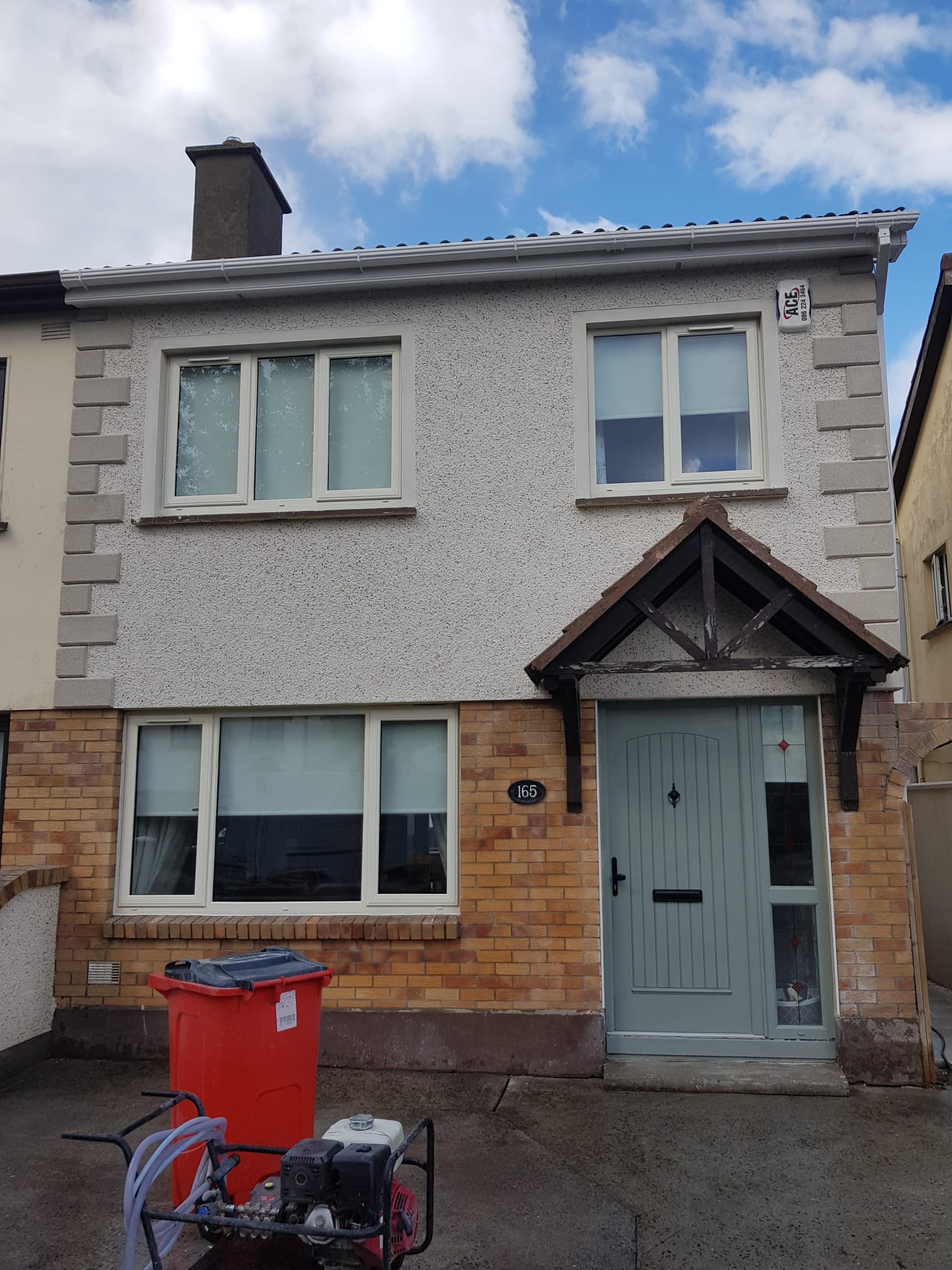 A house with a red trash can in front of it