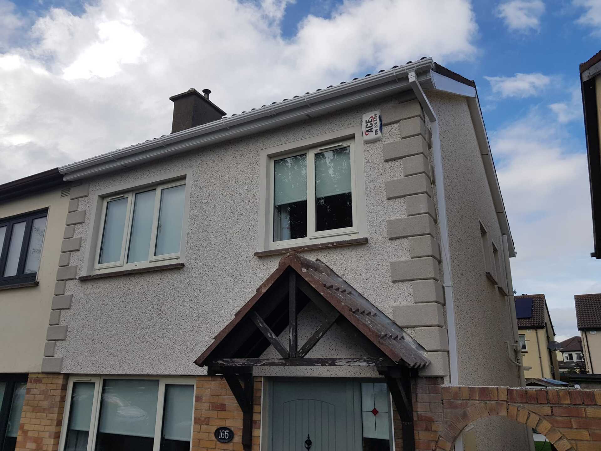 A white house with a wooden porch and a blue sky in the background
