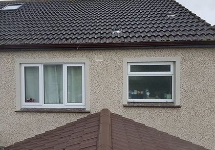 A house with two windows and a brown roof.