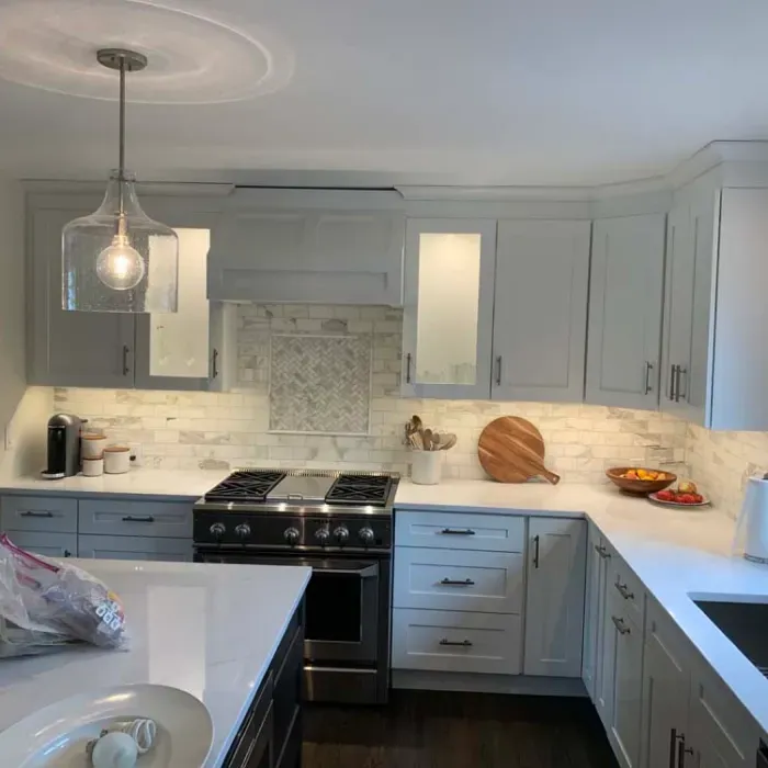 A kitchen with white cabinets and a stove top oven