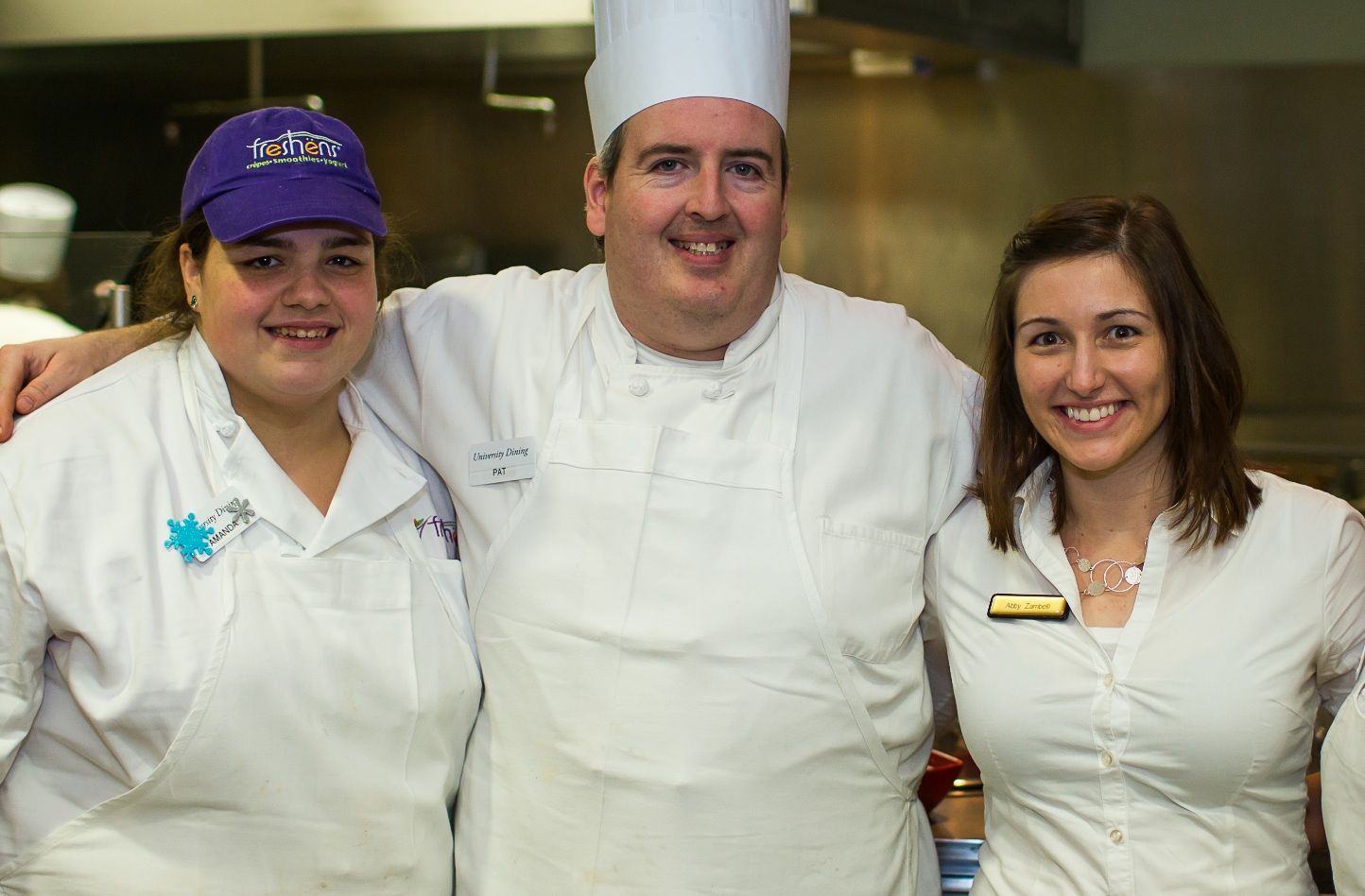 A man in a chef 's hat is posing for a picture with two other chefs