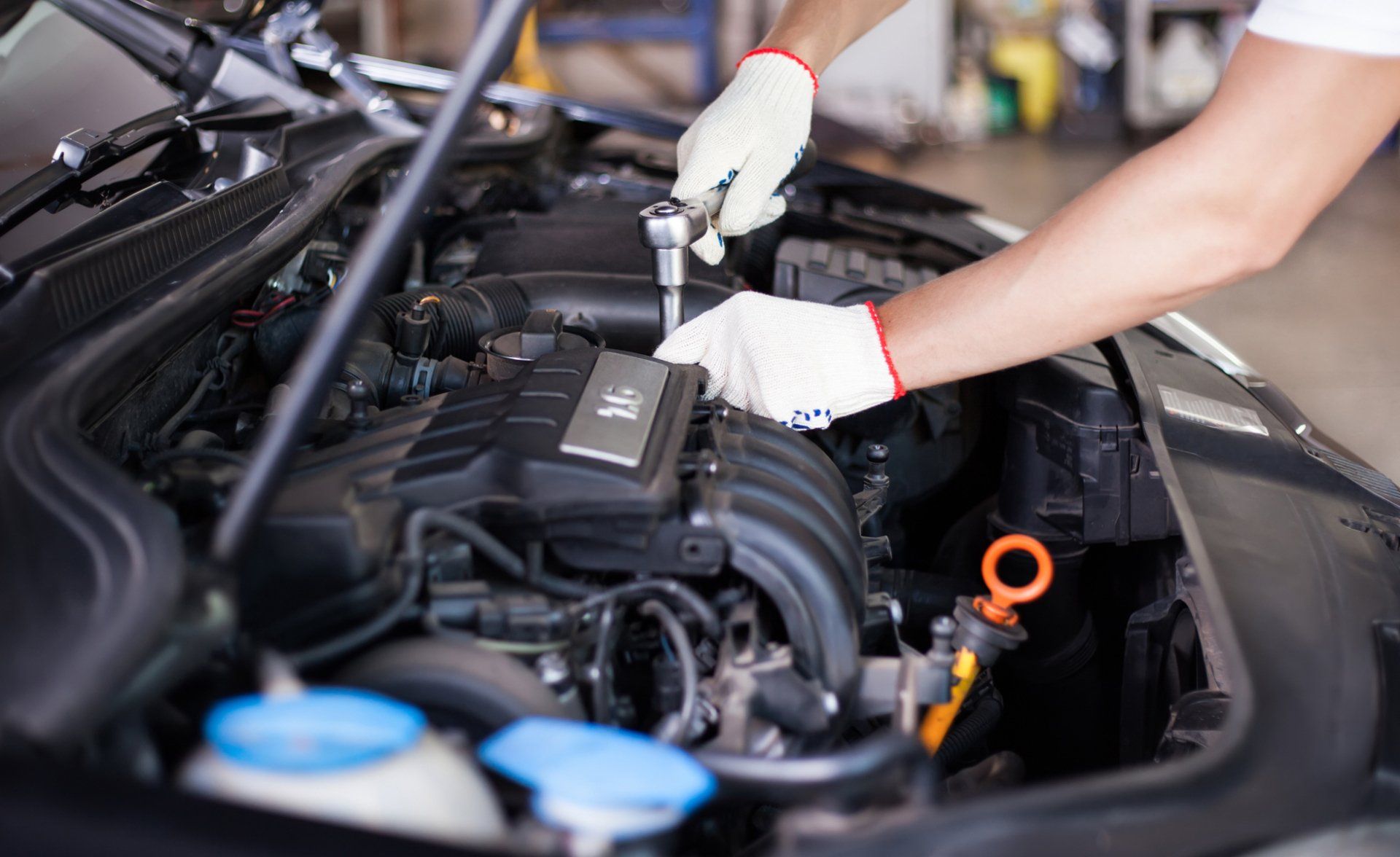 Hands of car mechanic in auto repair service.