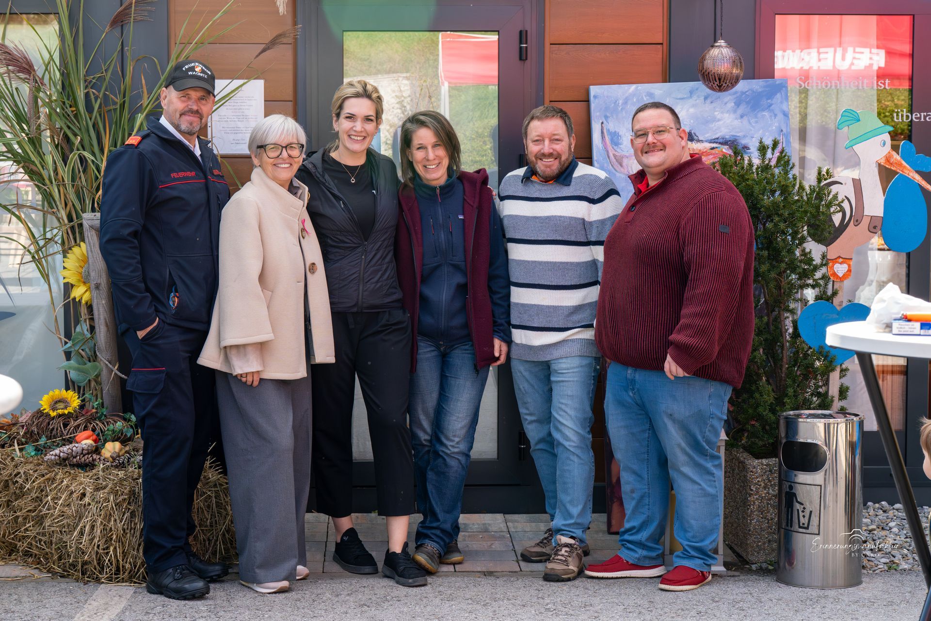 Eine Gruppe von Menschen posiert gemeinsam vor einem Gebäude.
