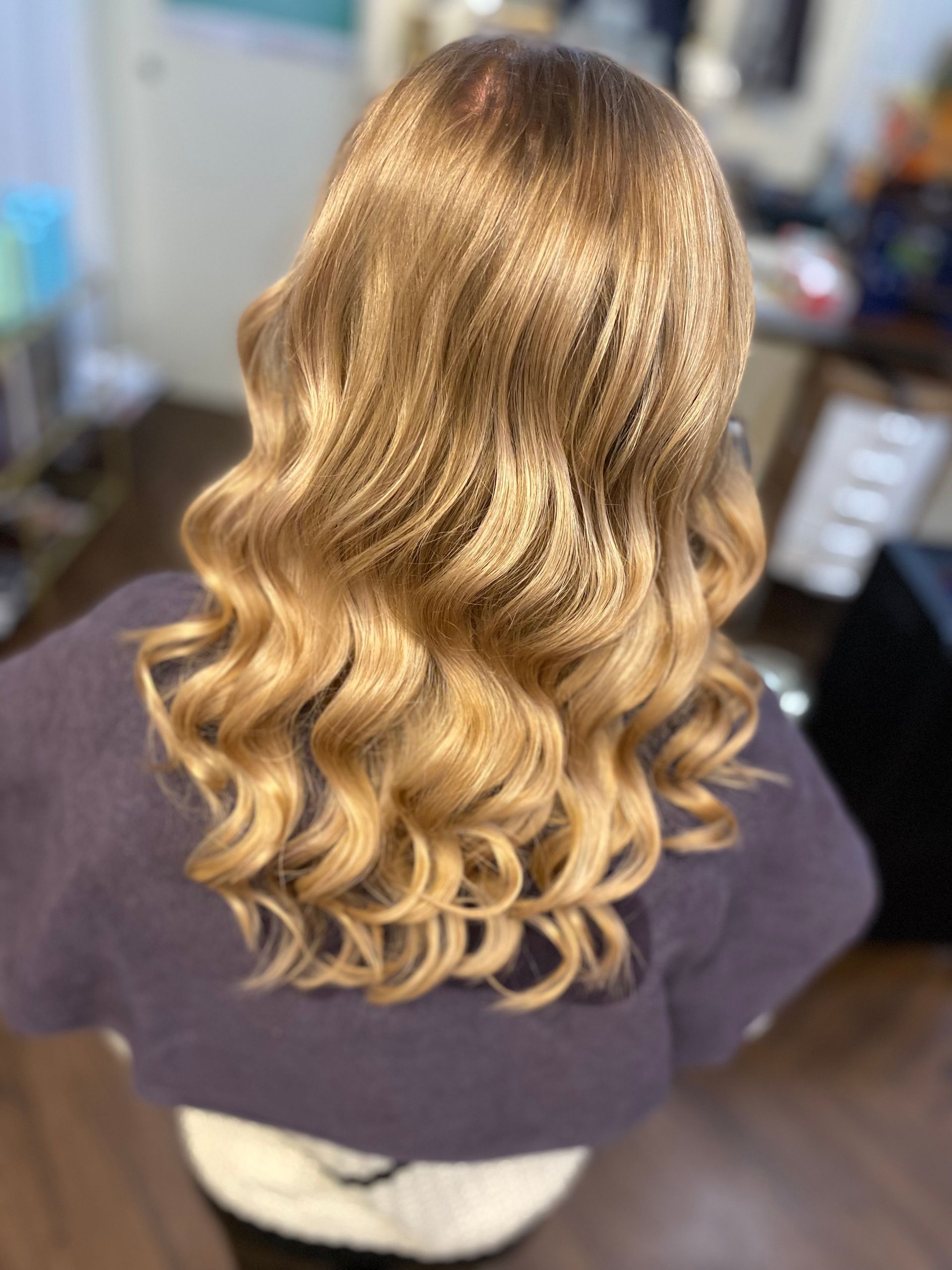 Blondes Haar, gestylt in Fingerwellen und voluminösen Locken; Ansicht von hinten.