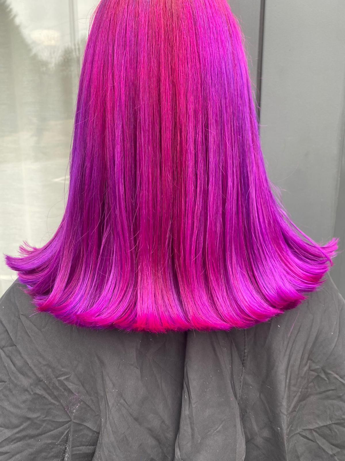 Lila-pinkes Ombré-Haar in einem stumpfen, schulterlangen Schnitt.