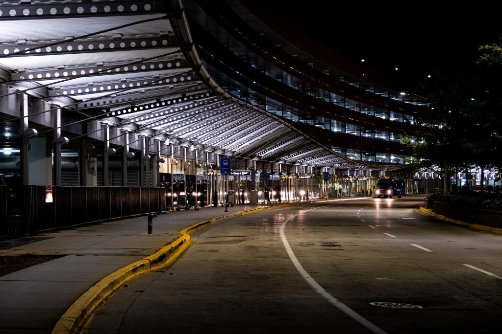 an empty street under a bridge at night .